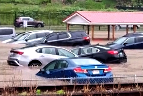Cars are submerged in a parking lot of Westernport Elementary School as flooding forces the evacuation of the school, and downtown homes and businesses were inundated with rising floodwaters in rural Westernport, Md., Tuesday, May 13, 2025.