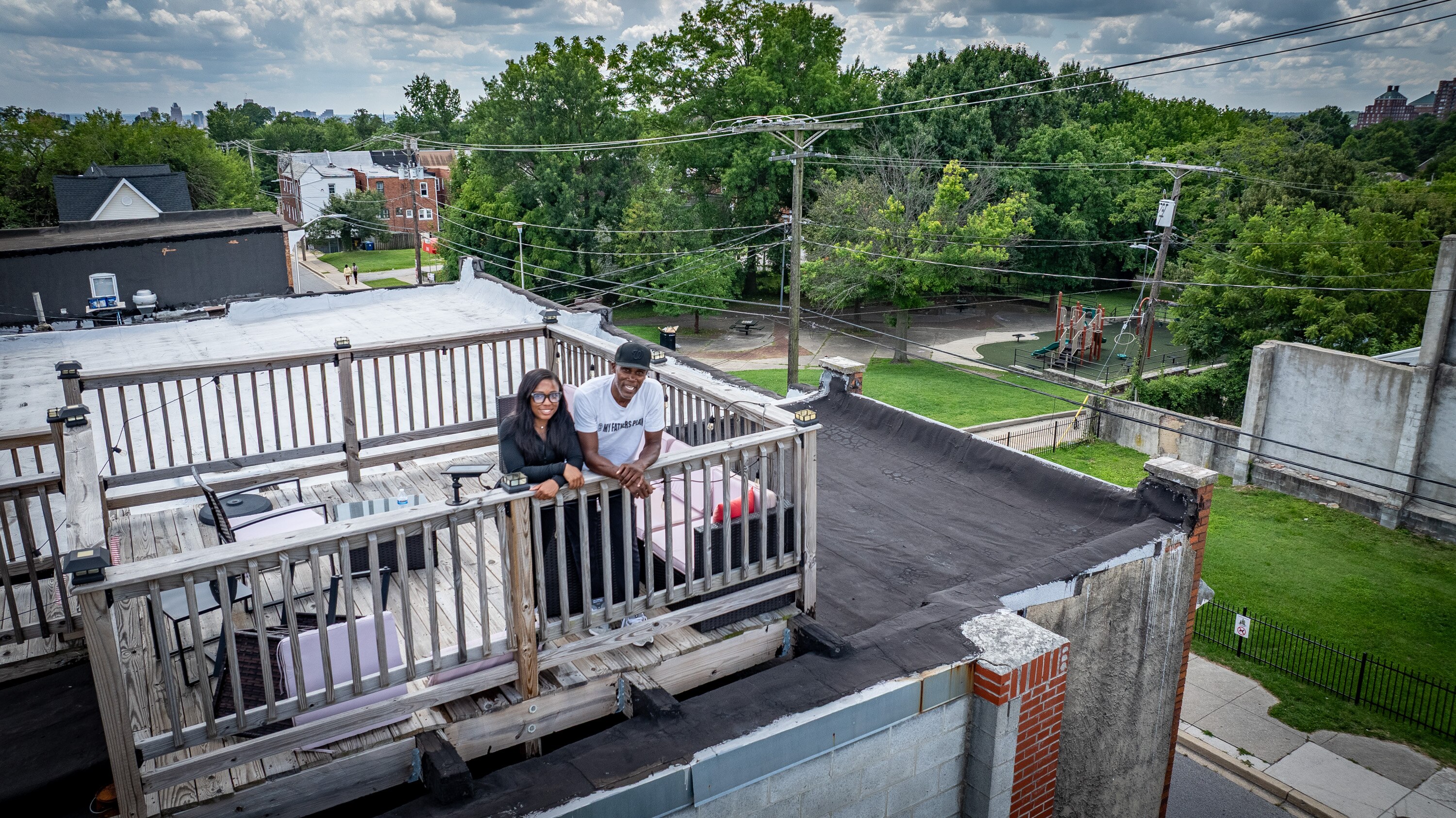 Aiyana Thomas and her father, Dawood, stand on the rooftop deck of their nonprofit, My Fathers Plan, in Baltimore’s Pen Lucy neighborhood.