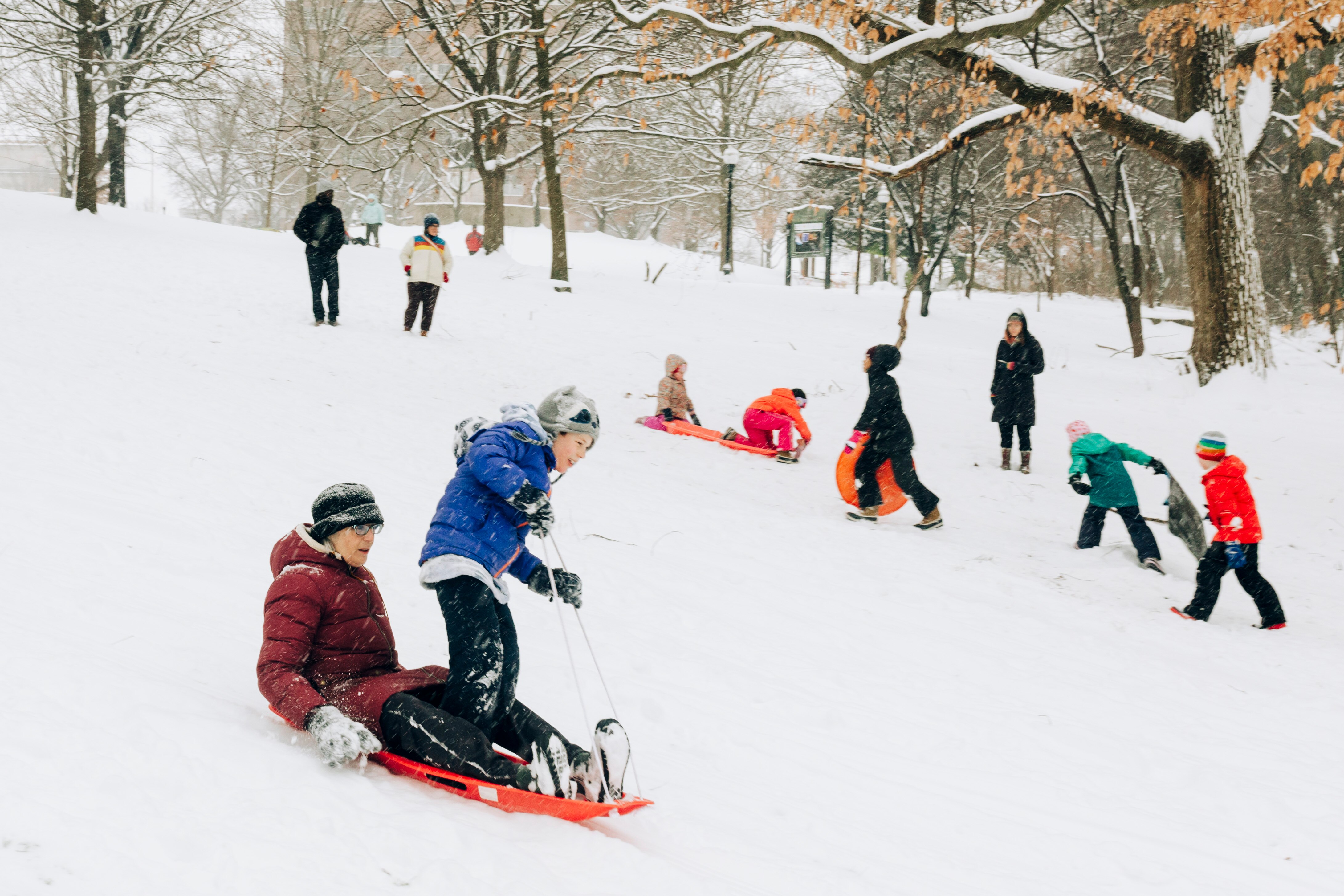 Battle Pincus, left, and Jack Kessinger sled down the hill at Wyman Park Dell on the morning after the first lasting snowfall of the winter, in Baltimore, MD on Monday, Jan. 6, 2025.