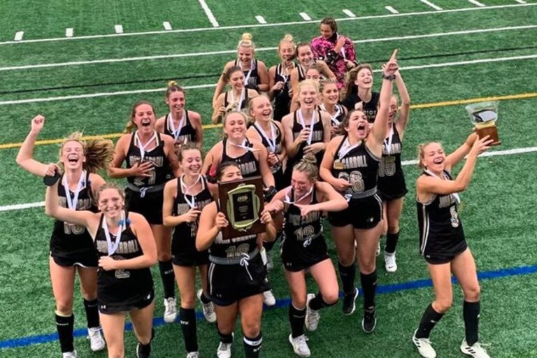 John Carroll celebrates after receiving the IAAM B Conference field hockey championship plaque and trophy Sunday afternoon. The Patriots won their second title in three seasons with a 1-0 victory over Mercy at Stevenson University.