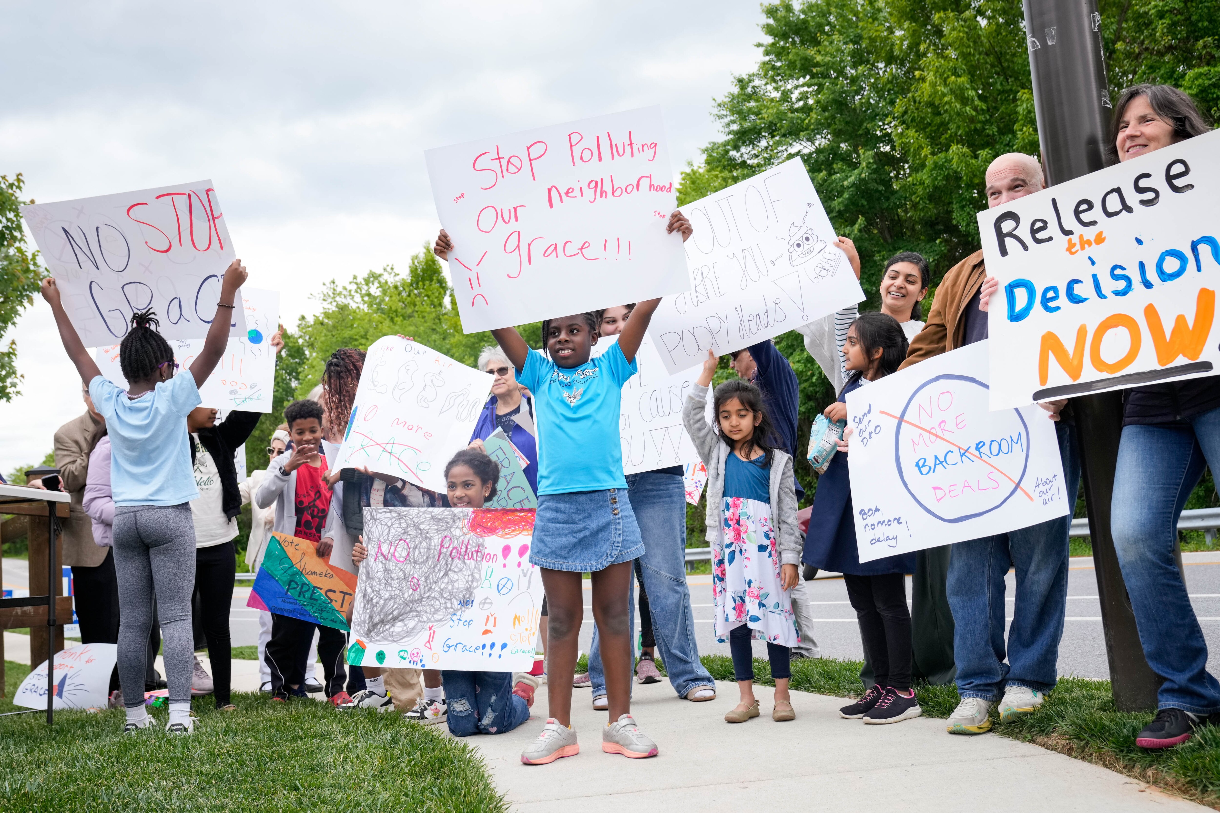 Protesters with the Stop Grace Coalition hold signs during a rally near the W.R. Grace headquarters in Columbia on Thursday.