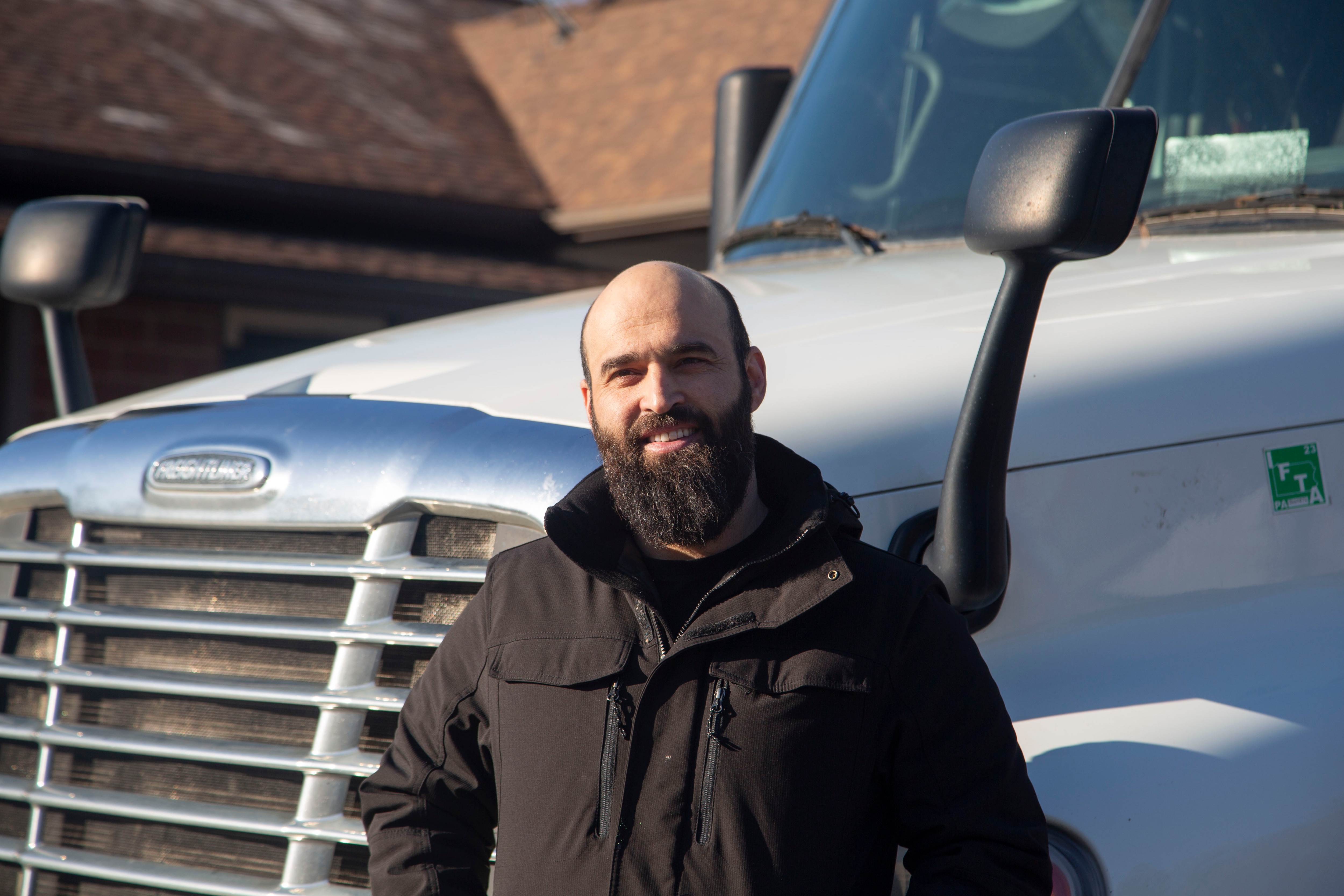 Mohammad stands before his truck, that he calls a good friend, which provided the essential capital from driving four years cross country to provide the funds to open Bamyan Halal Meat international grocery market in Columbia.