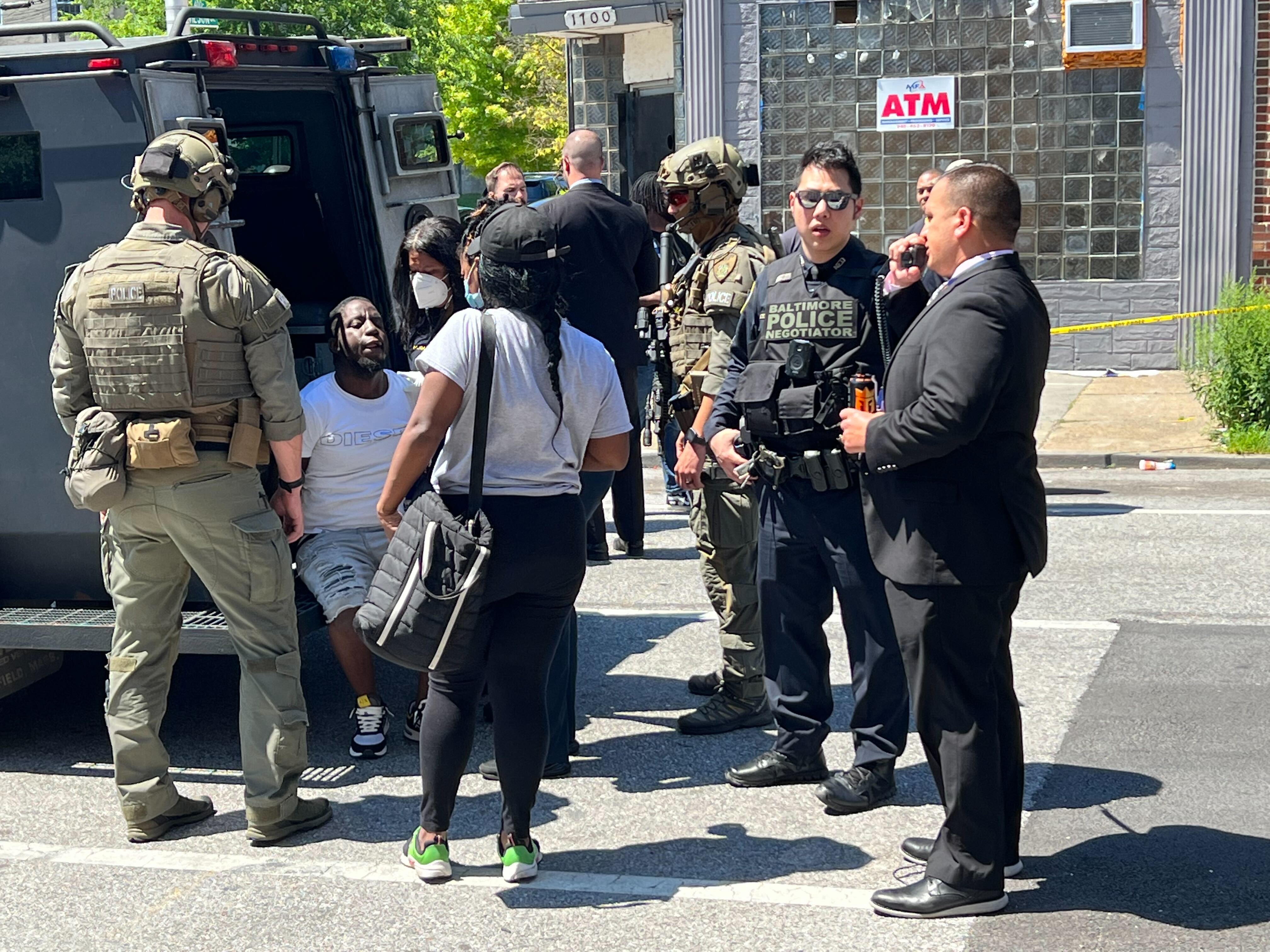Baltimore Police take a suspect into custody in the case of a sergeant who police and witnesses say was dragged by a vehicle while conducting a traffic stop.