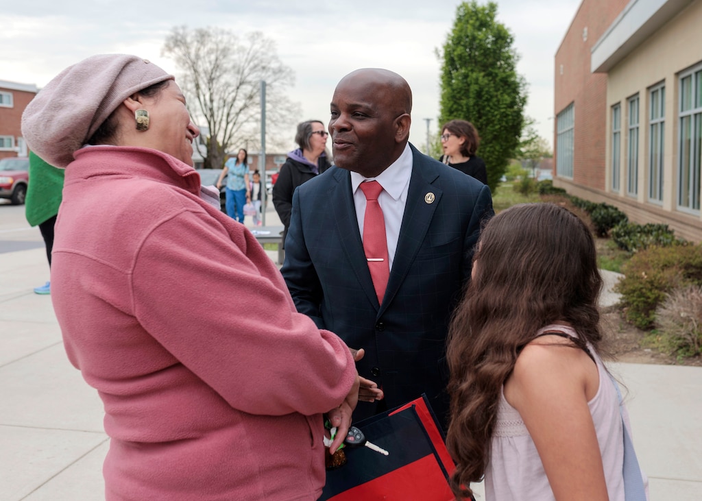 Dr. Jermaine Dawson, the new CEO of Baltimore City Public Schools, chats with Dee Abdelkader and her daughter Jasmine, who is in 4th grade, outside of Medfield Heights Elementary School.