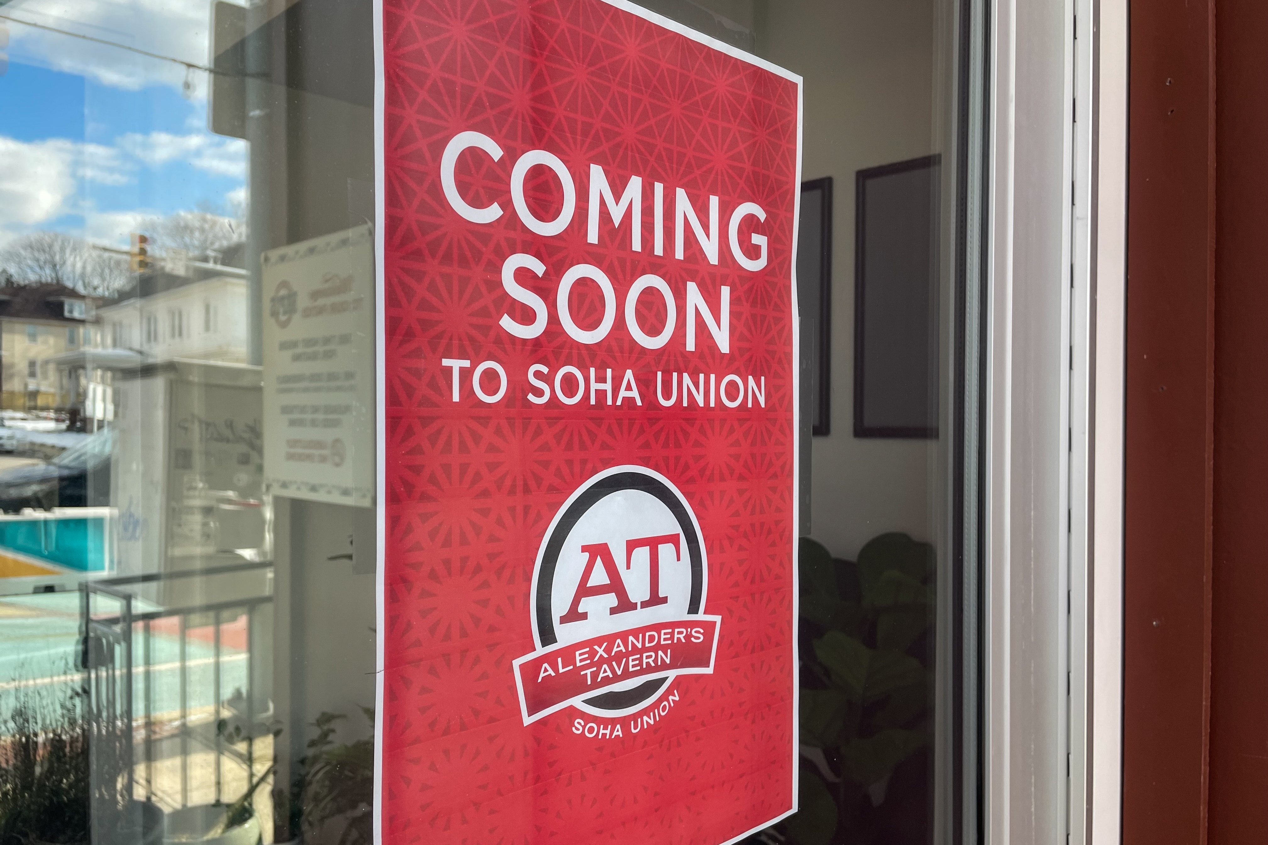 A sign indicates the impending opening of Alexander’s Tavern on Harford Road.