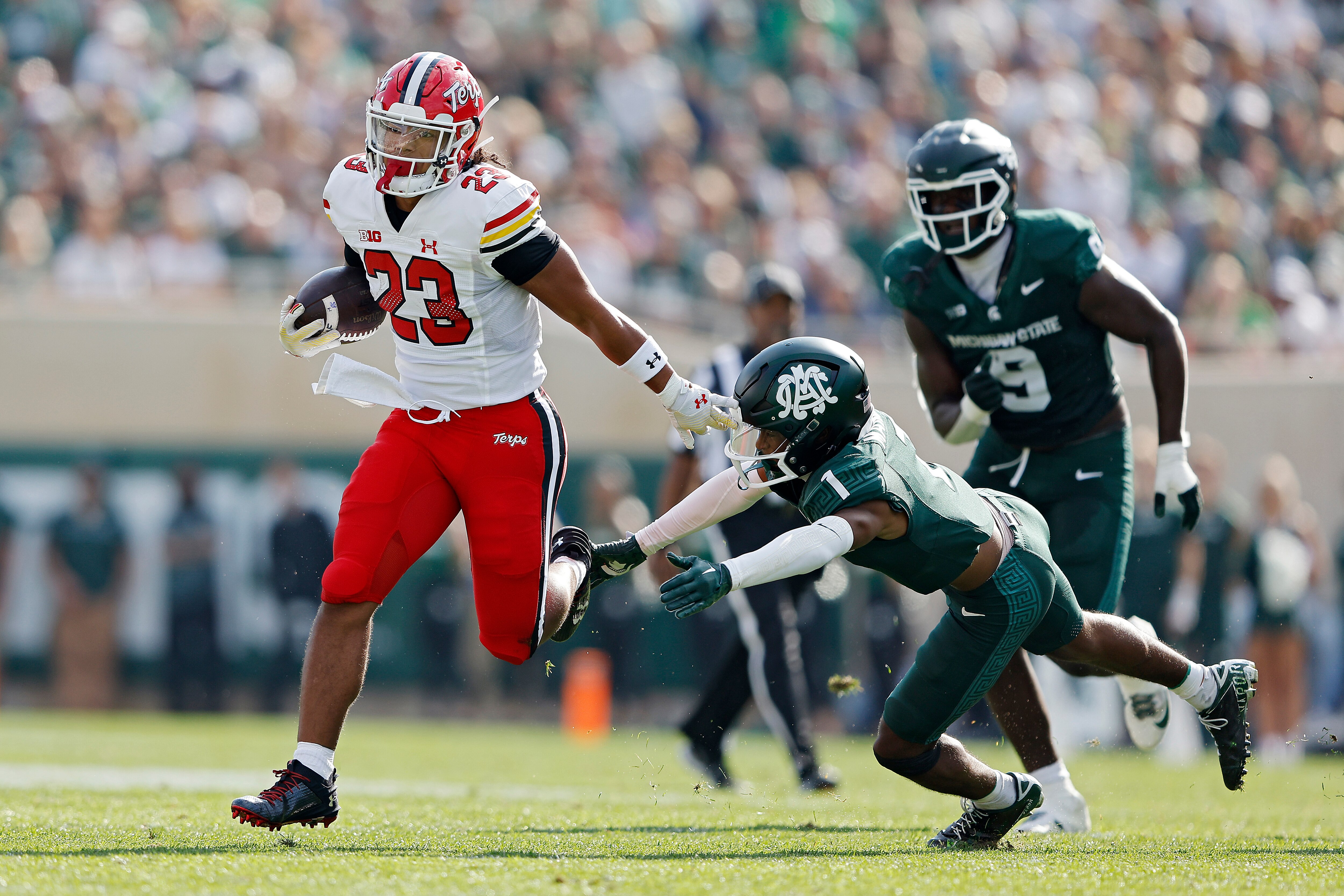 Colby McDonald of Maryland runs past Jaden Mangham of Michigan State during the Terrapins' Big Ten road win Saturday.