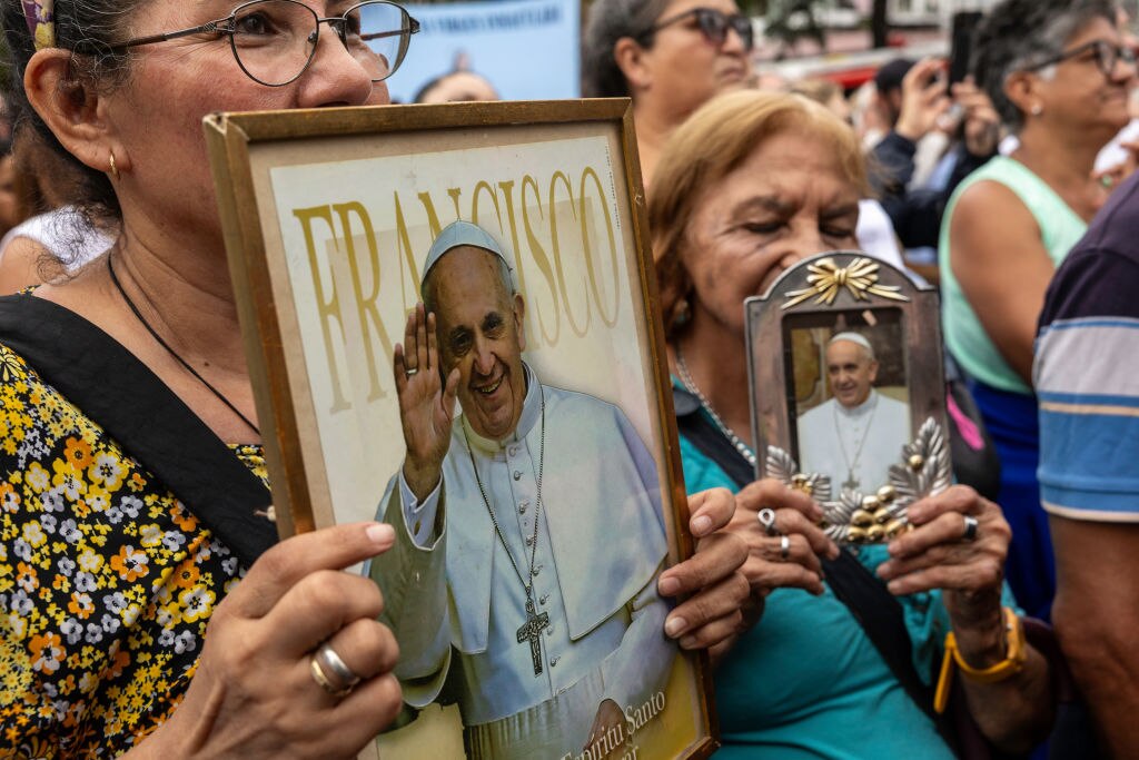 Catholic faithful carry images of Pope Francis at an outdoor mass to pray for him on February 24, 2025 in Buenos Aires, Argentina.