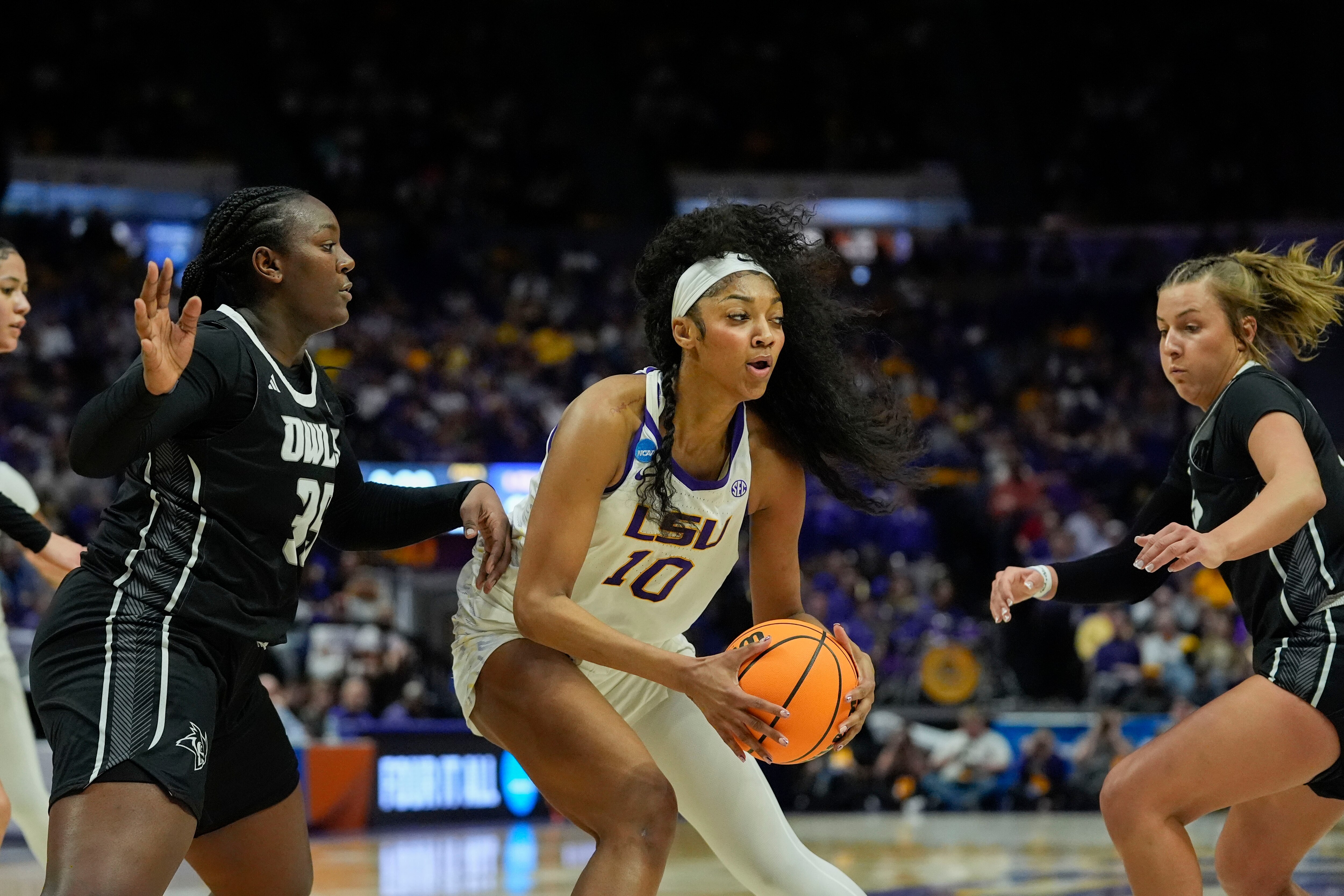 LSU forward Angel Reese looks to pass between two Rice defenders Friday during the first round of the NCAA tournament.