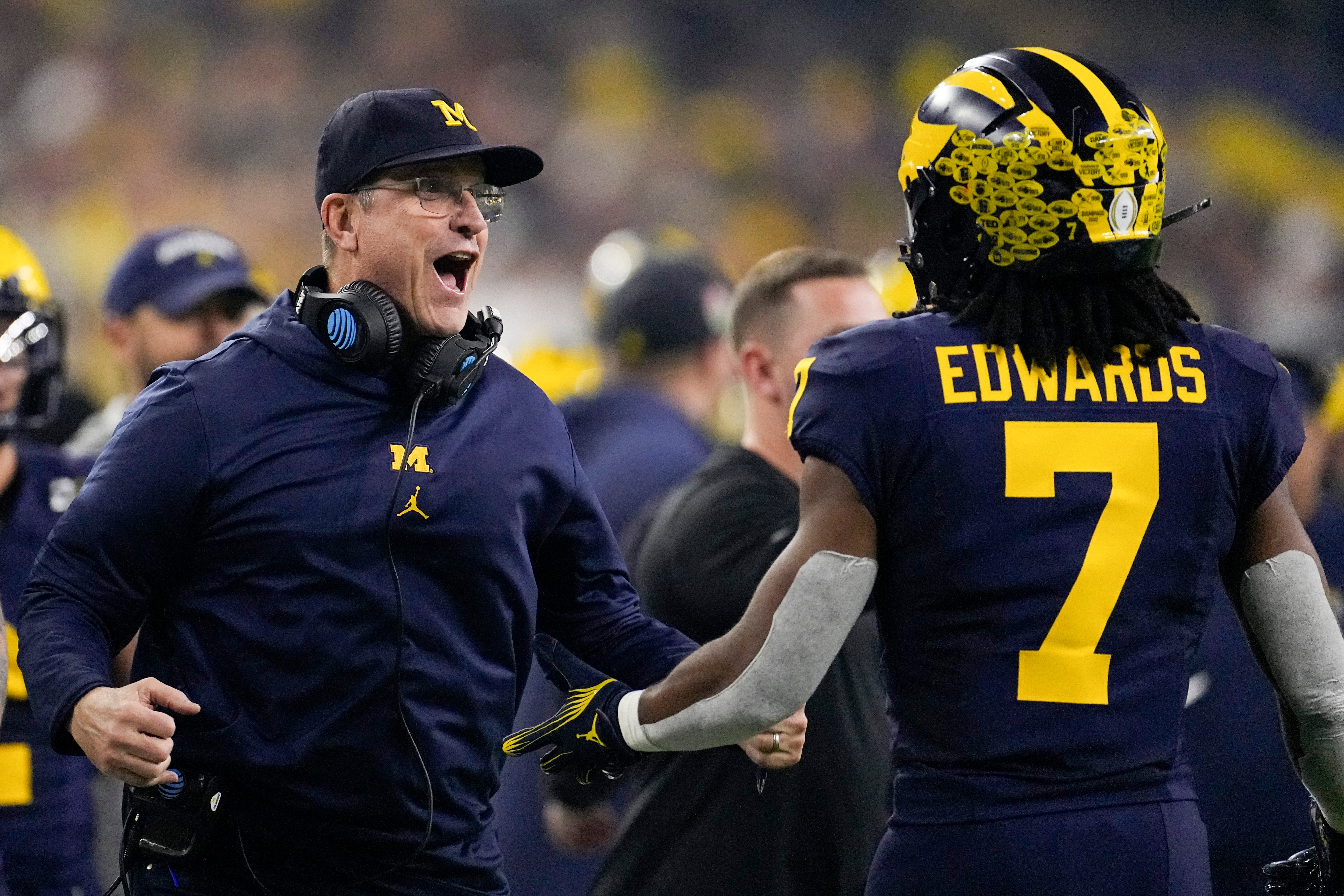 Michigan running back Donovan Edwards celebrates after scoring with head coach Jim Harbaugh during the first half of the national championship NCAA College Football Playoff game against Washington Monday, Jan. 8, 2024, in Houston. (AP Photo/David J. Phillip)