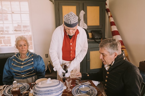 Living history volunteer, Will White serves faux wine at the six-course meal, showcasing authentic Revolutionary War-era diningon September 8th, 2024, at Fort McHenry in Baltimore City.