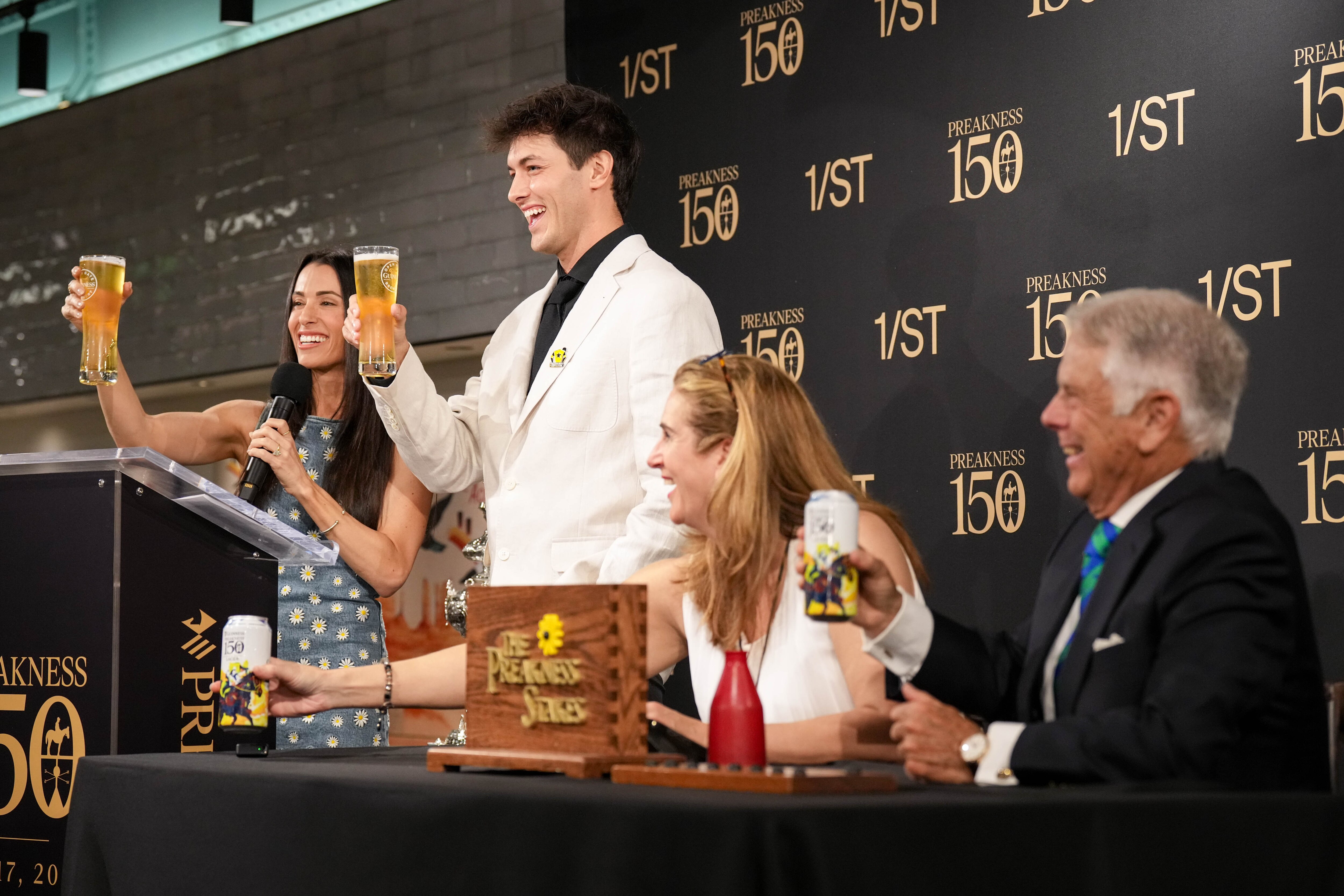 Griffin Johnson, second from left, co-owner of Sandman, joins a toast at the conclusion of the Preakness 150 Post Position Draw.