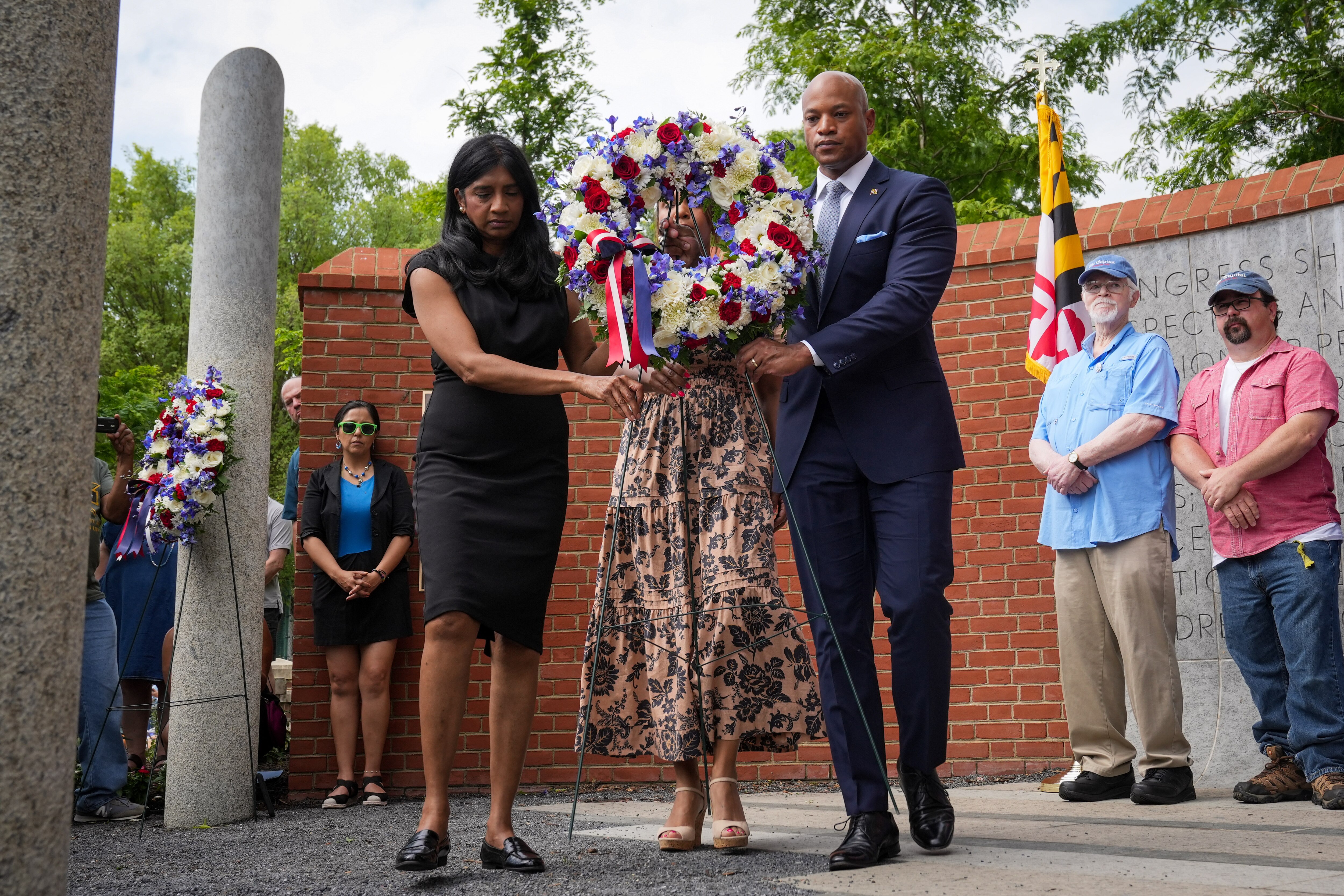 Gov. Wes Moore, Lt. Gov. Aruna Miller and Maryland first lady Dawn Moore lay a wreath during a ceremony memorializing the victims of the 2018 Capital Gazette shooting Wednesday in Annapolis.