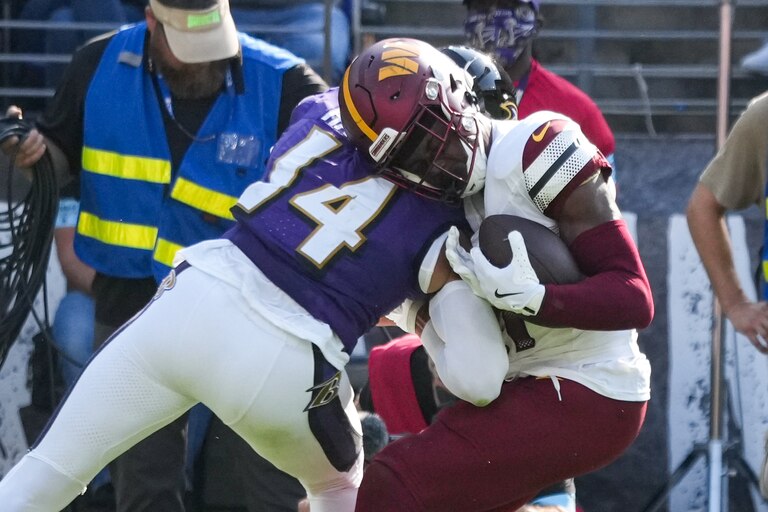 Baltimore Ravens safety Kyle Hamilton (14) lands a big hit on Washington Commanders wide receiver Terry McLaurin (17) near the sidelines at M&T Bank Stadium in Baltimore on Sunday, October 13, 2024.