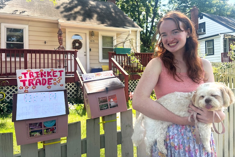 Jojo Craven poses with her dog, Halo, outside her trinket library outside her house on Veirs Mill Road in Rockville on Wednesday.