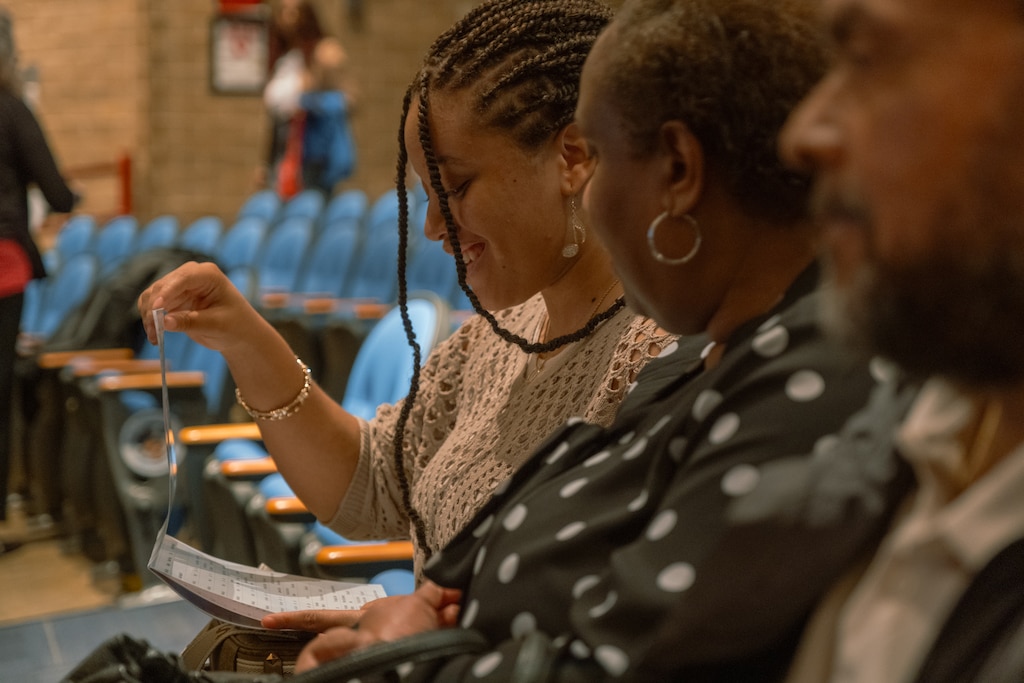 Kaliyah Fletcher, 17, looks through the program guide with her parents, Patricia and Anthony Fletcher, prior to the award ceremony for the Prince George's County's Write-A-Book contest.