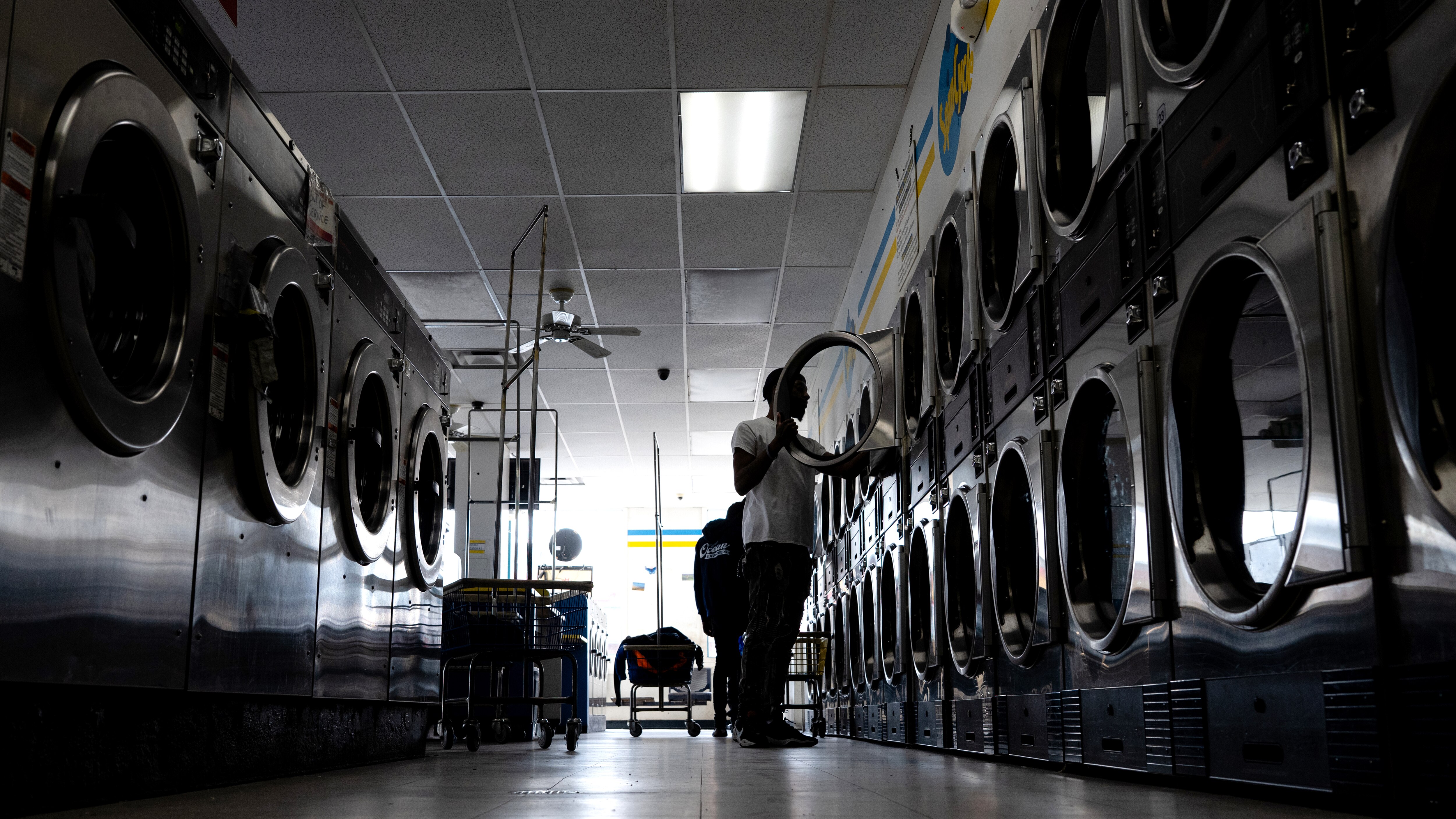 Customers use the washing machines at Spin Cycle Coin Laundry in Baltimore.