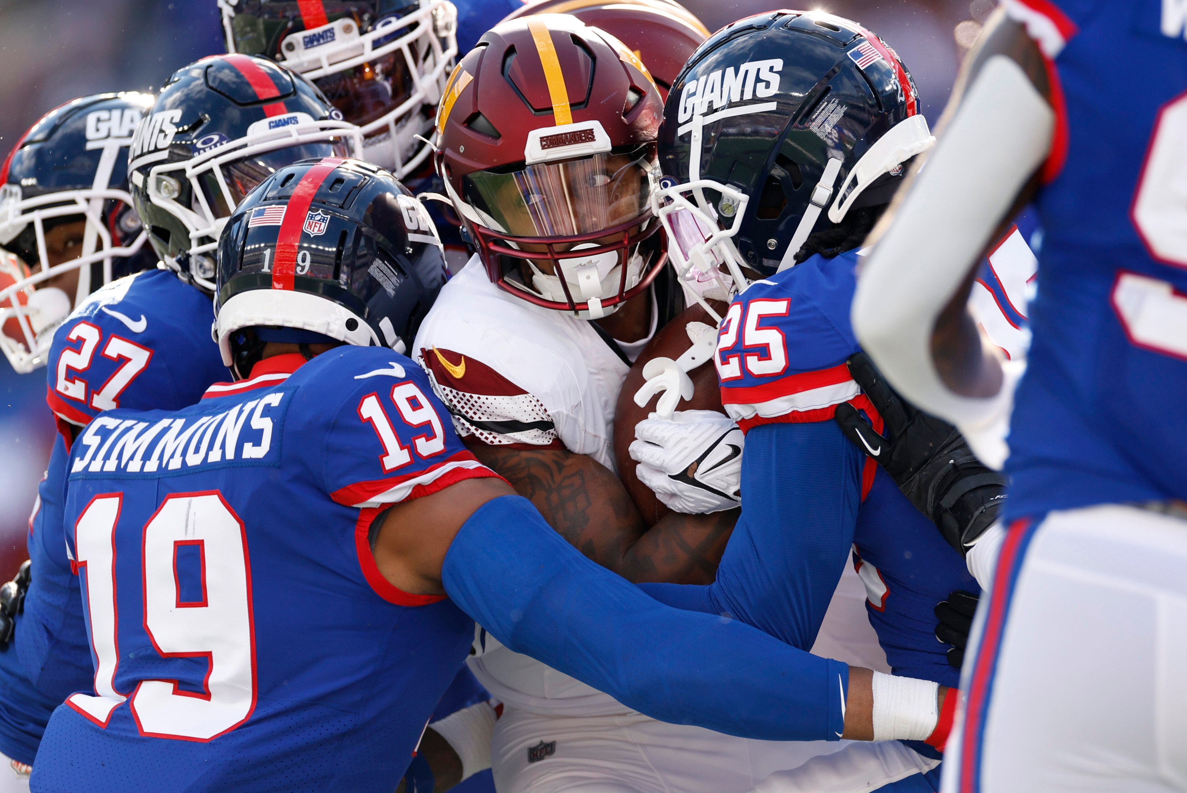 A group of New York Giants tackles Antonio Gibson of the Commanders during the fourth quarter of Washington's 14-7 loss Sunday.