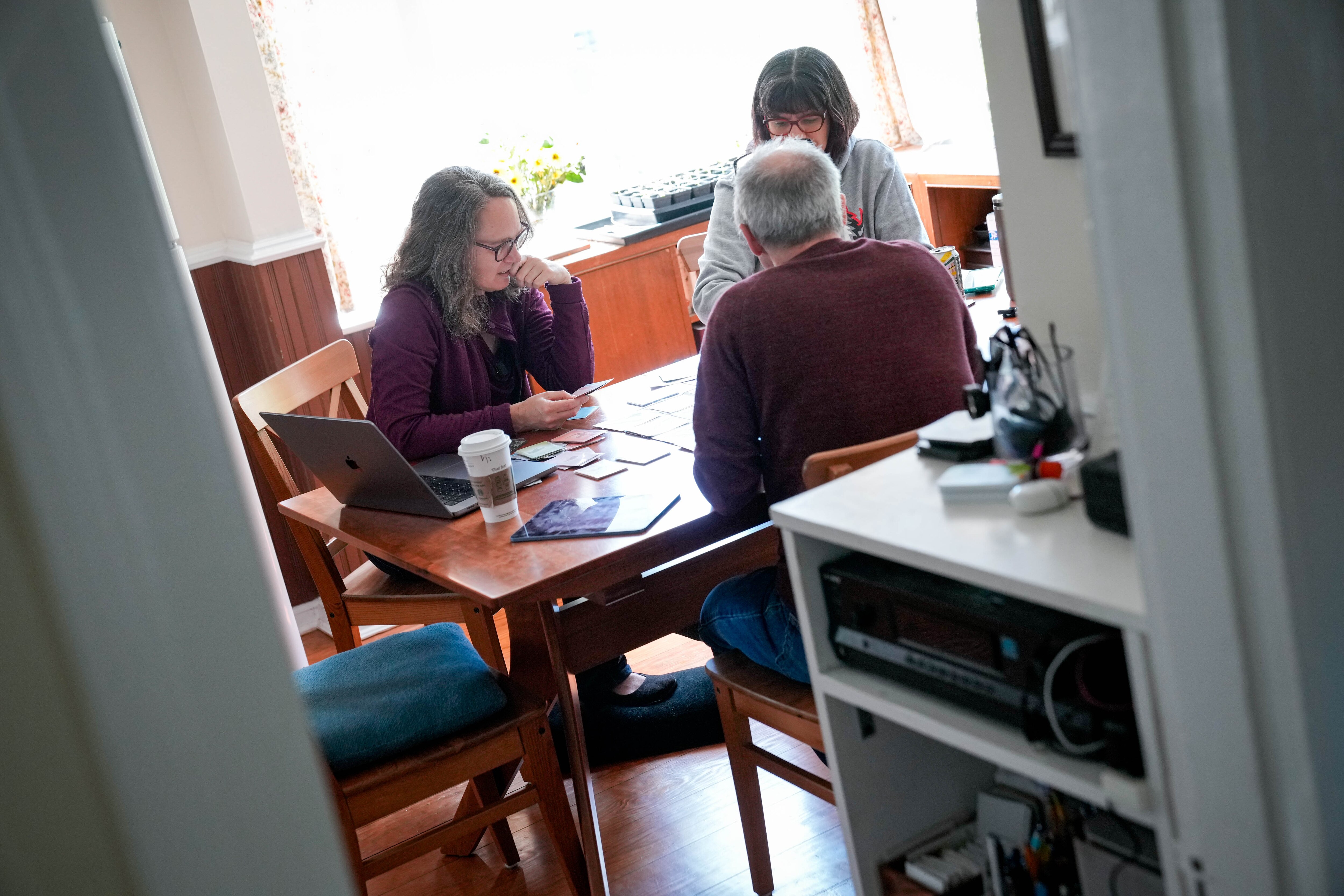 Wingspan designer Elizabeth Hargrave, left, play-tests an untitled sorting board game project at her home in Silver Spring with fellow designers Dominic Crapuchettes and Connie Vogelmann.