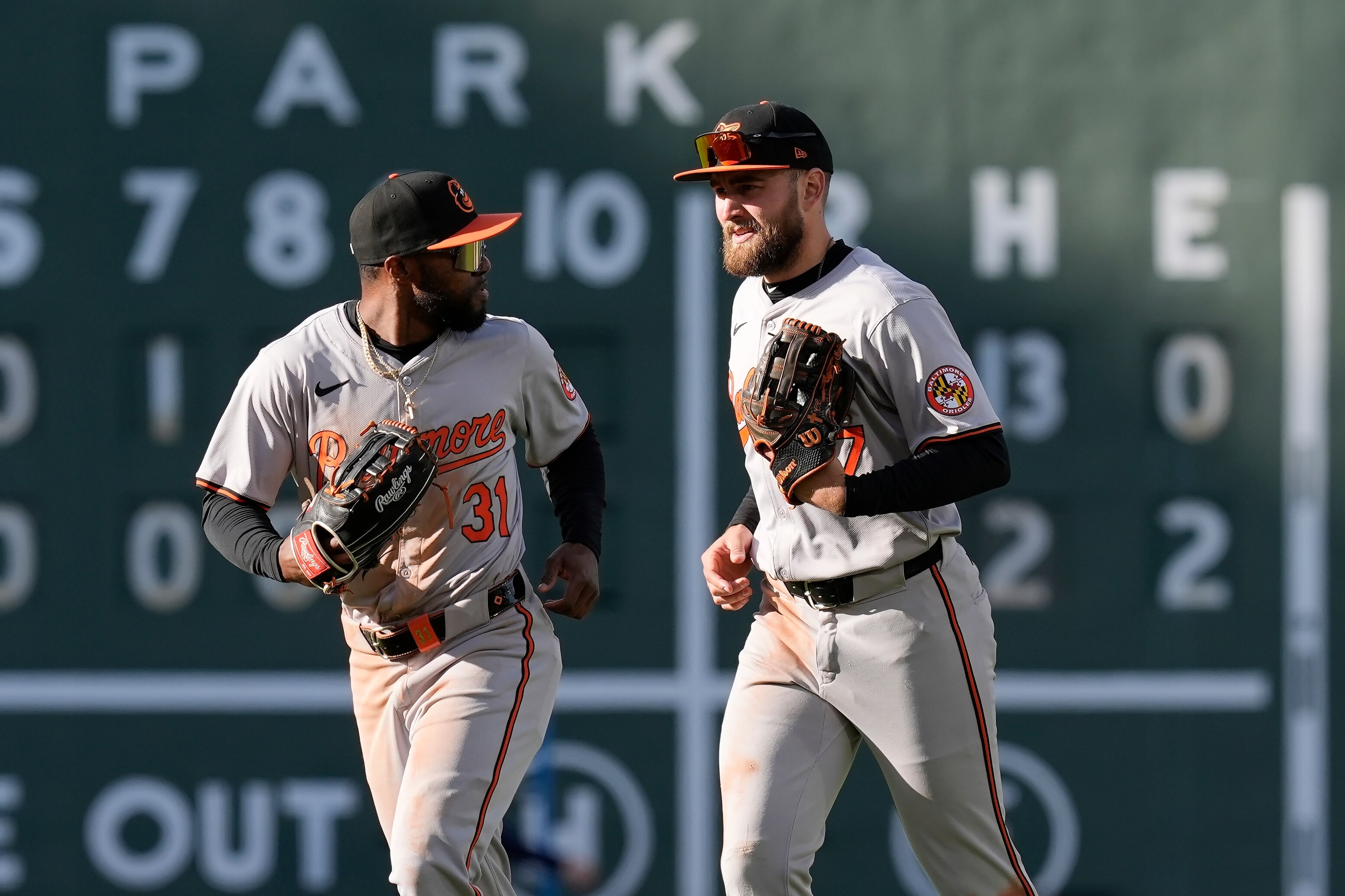 Baltimore Orioles Cedric Mullins (31) and Colton Cowser run past the scoreboard after defeating the Boston Red Sox during an opening-day baseball game at Fenway Park.