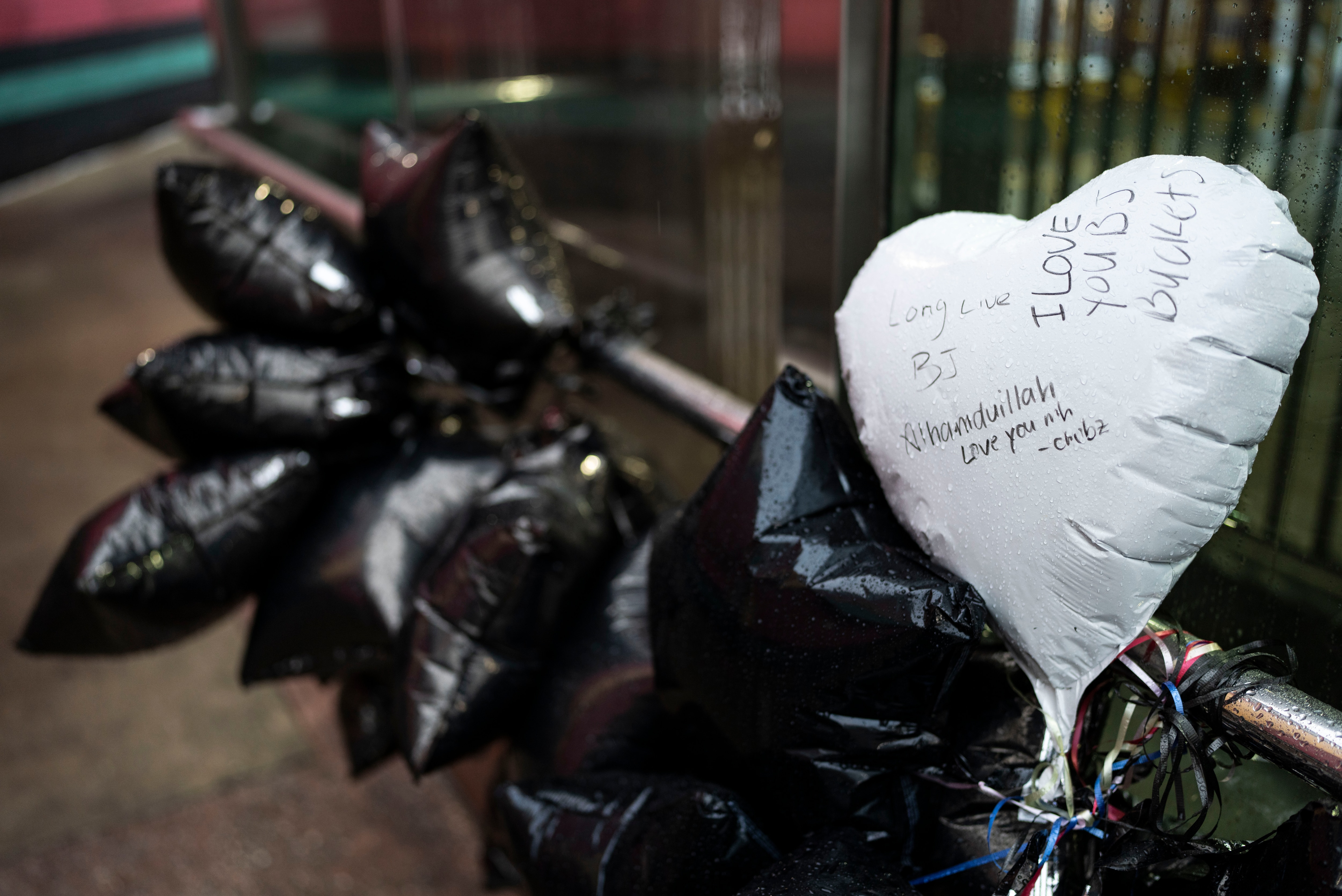 Balloons tied to the railing outside Upton–Avenue Market Metro station on Thursday to honor Bilal “BJ” Abdullah, who was fatally shot by Baltimore Police this week.