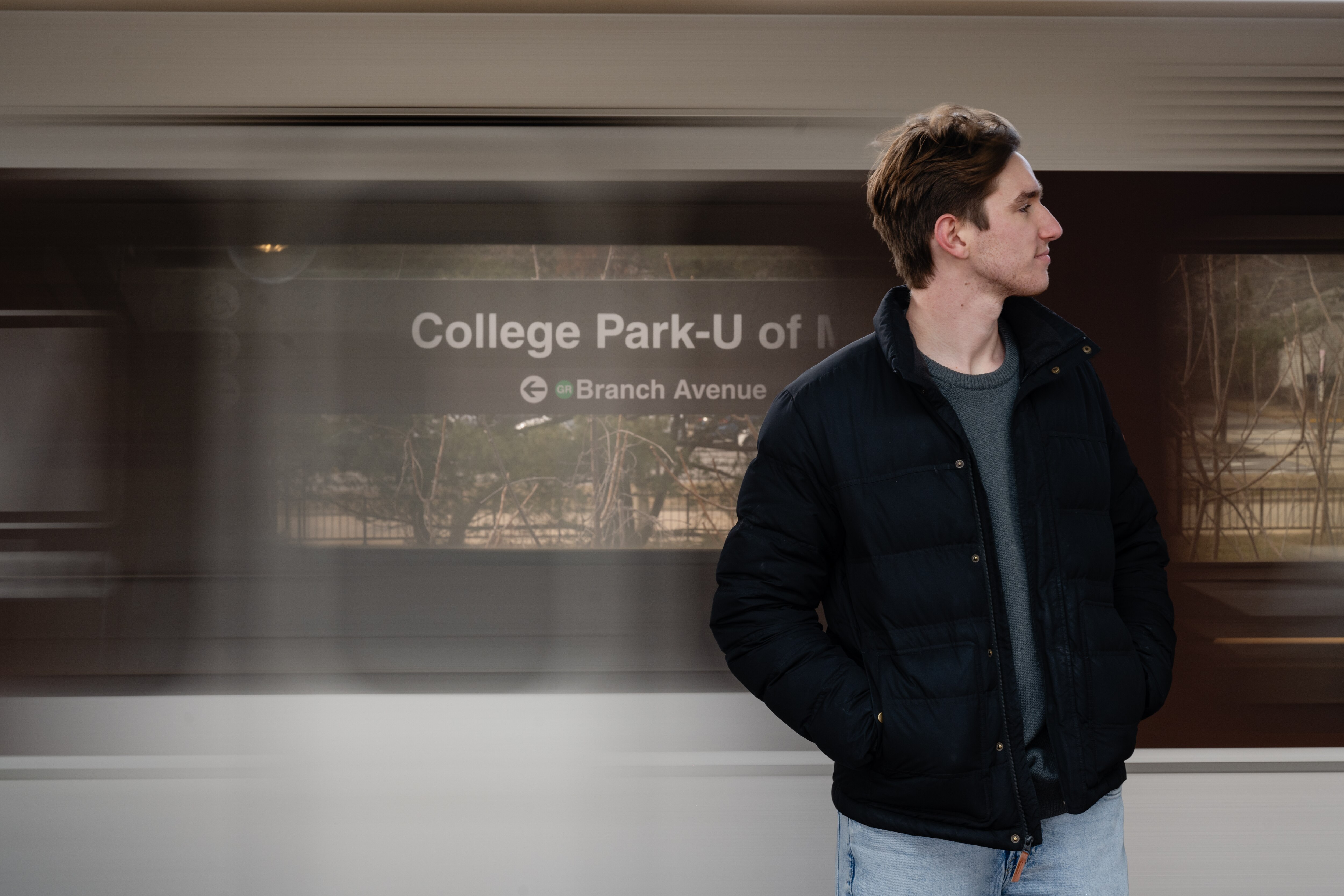 Gannon Sprinkle, Candidate for College Park City Council, stands by a Metro train while out campaigning on February 9th, 2025 in College Park, MD.