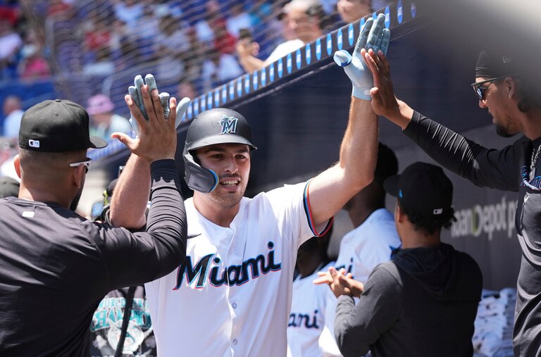 Matt Mervis is pictured receiving high fives in the Miami Marlins' dugout after a home run.