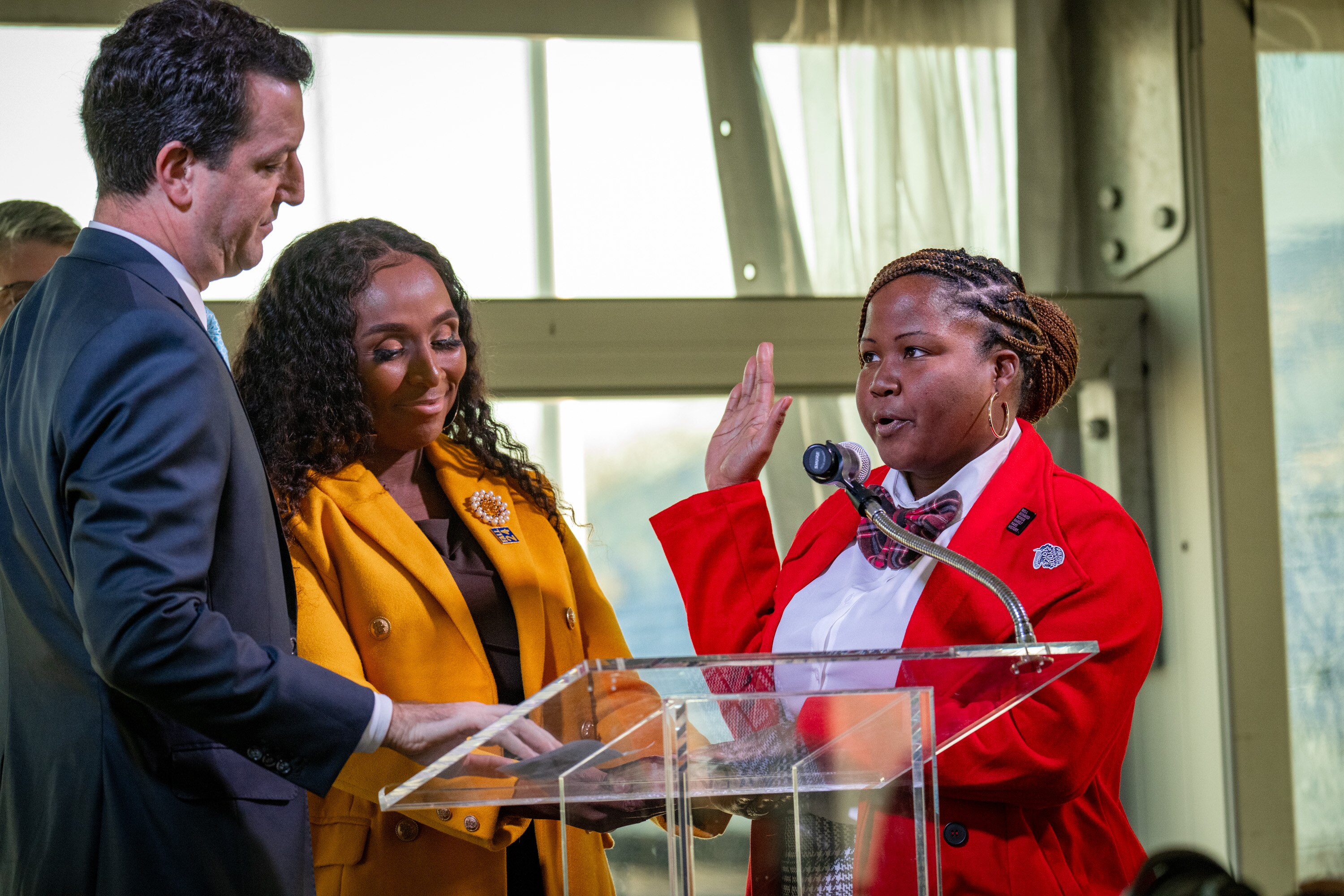 Annapolis Mayor Jared Littmann, left, administers the oath of office to Alderwoman Diesha Contee during inauguration ceremonies Monday at Navy-Marine Corps Memorial Stadium. State Sen. Shaneka Henson, a former alderwoman from Contee’s ward, holds the Bible.