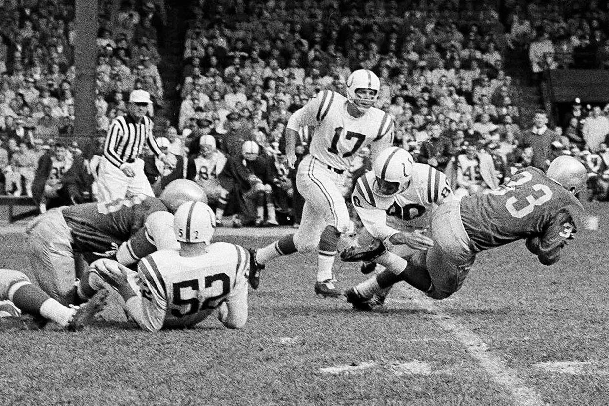 Baltimore Colts back Andy Nelson (80) tackles Detroit Lions back Nick Pietrosante (33) in the first quarter to break up a run that netted the Lions only eight yards on Oct. 11, 1959 in Detroit.