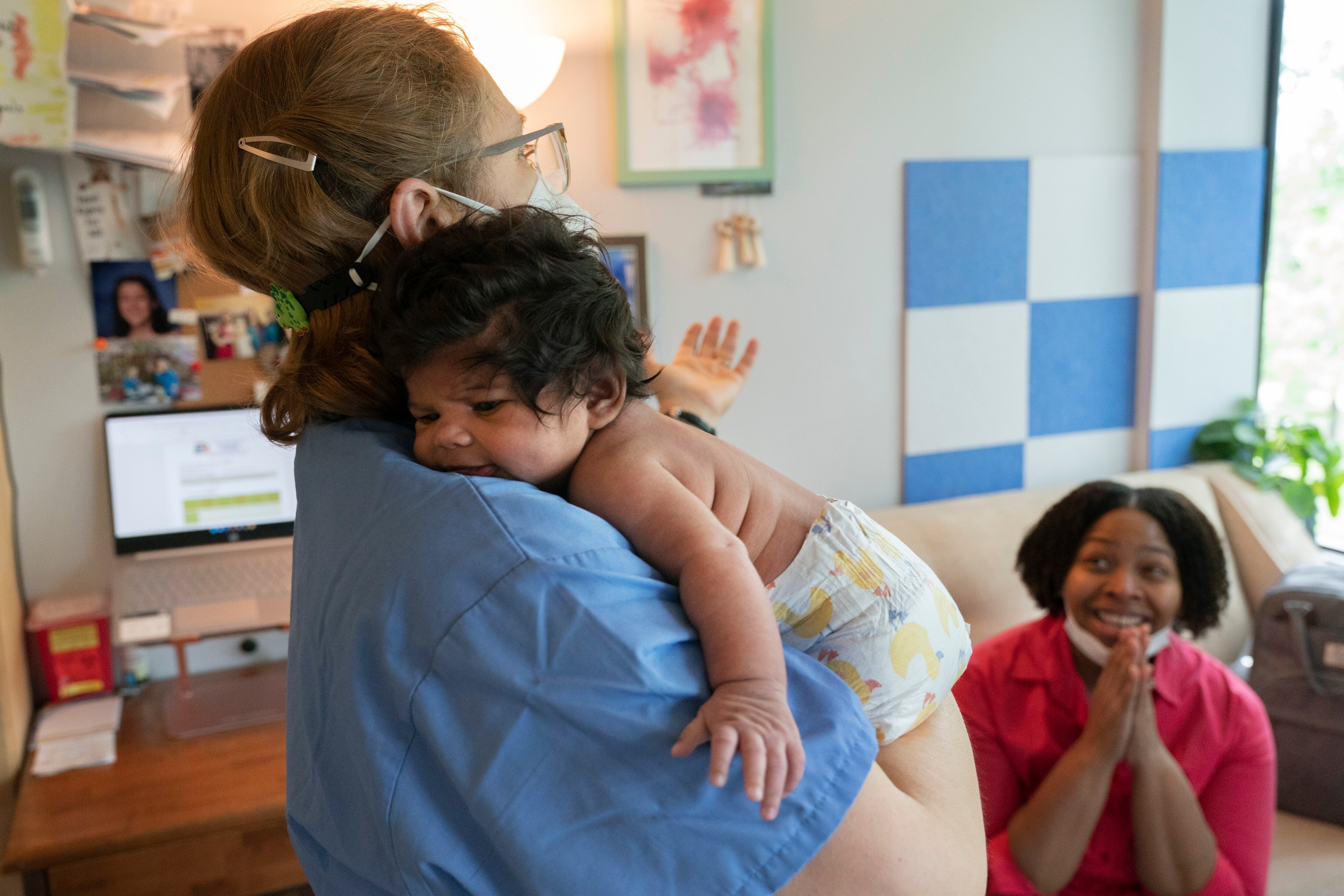 Capri Isidoro, of Ellicott City, claps on hearing reassuring advice from Ann Faust, an International Board Certified Lactation Consultant, holding Isidoro’s one-month-old baby Charlotte, Monday, May 23, 2022, in Columbia during a lactation consult at Baby and Me Lactation Services.