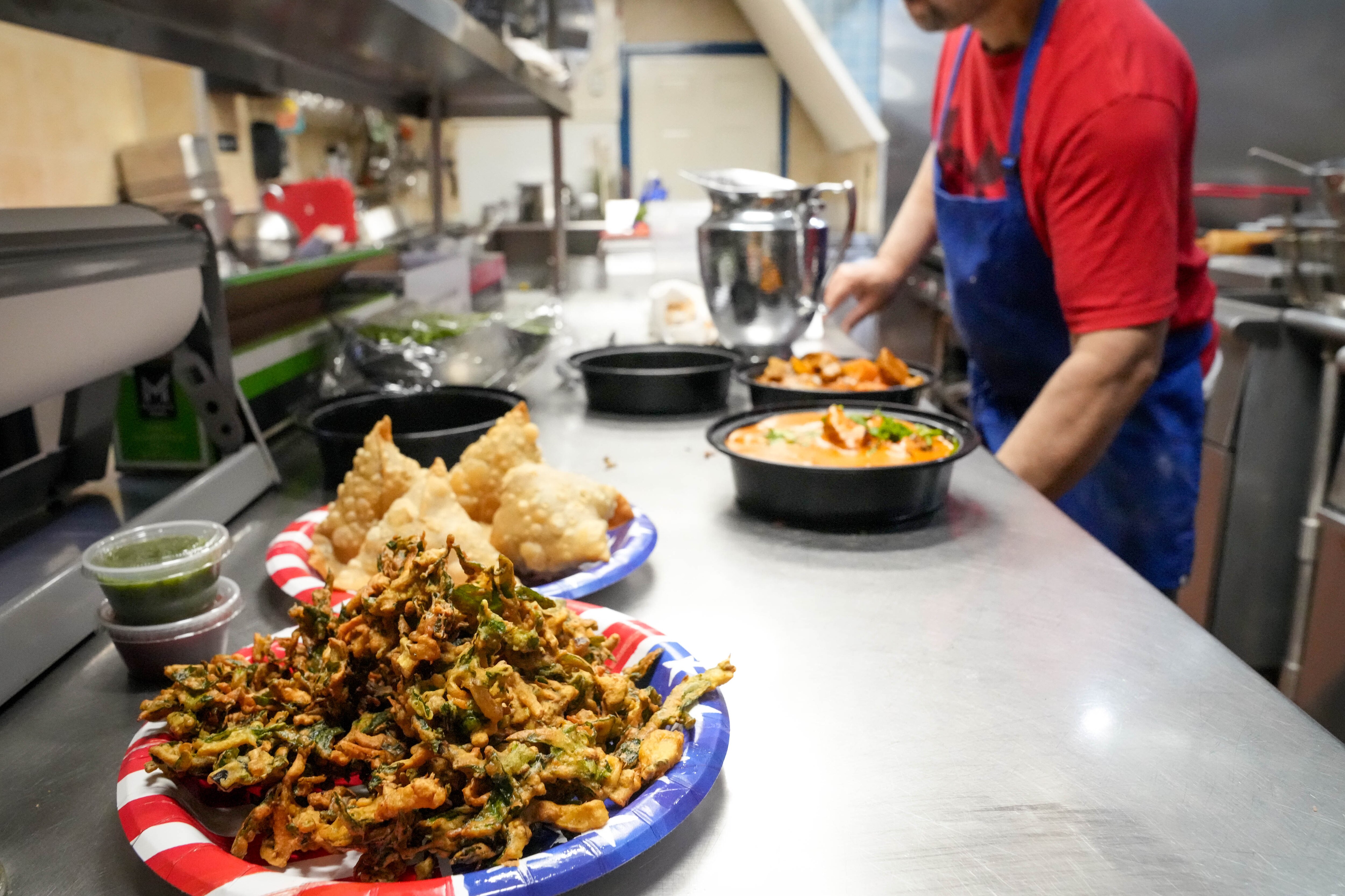 Head chef Gurnek Bassi plates a customer’s order in the kitchen at India Tandoor in Baltimore.