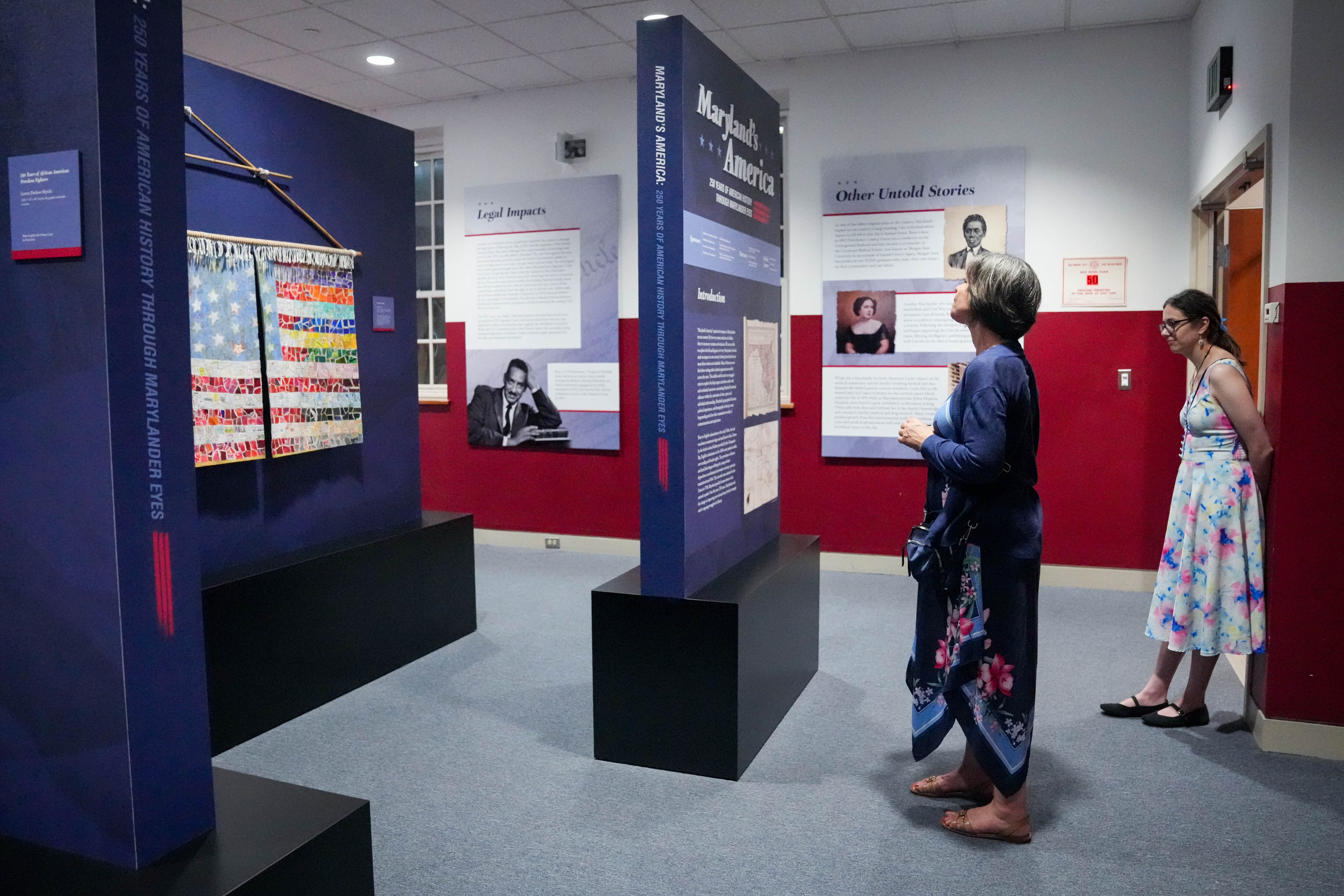 Artists and guests examine the artwork during the unveiling of the “Maryland’s America” exhibit at the Star-Spangled Banner Flag House in Baltimore last week.