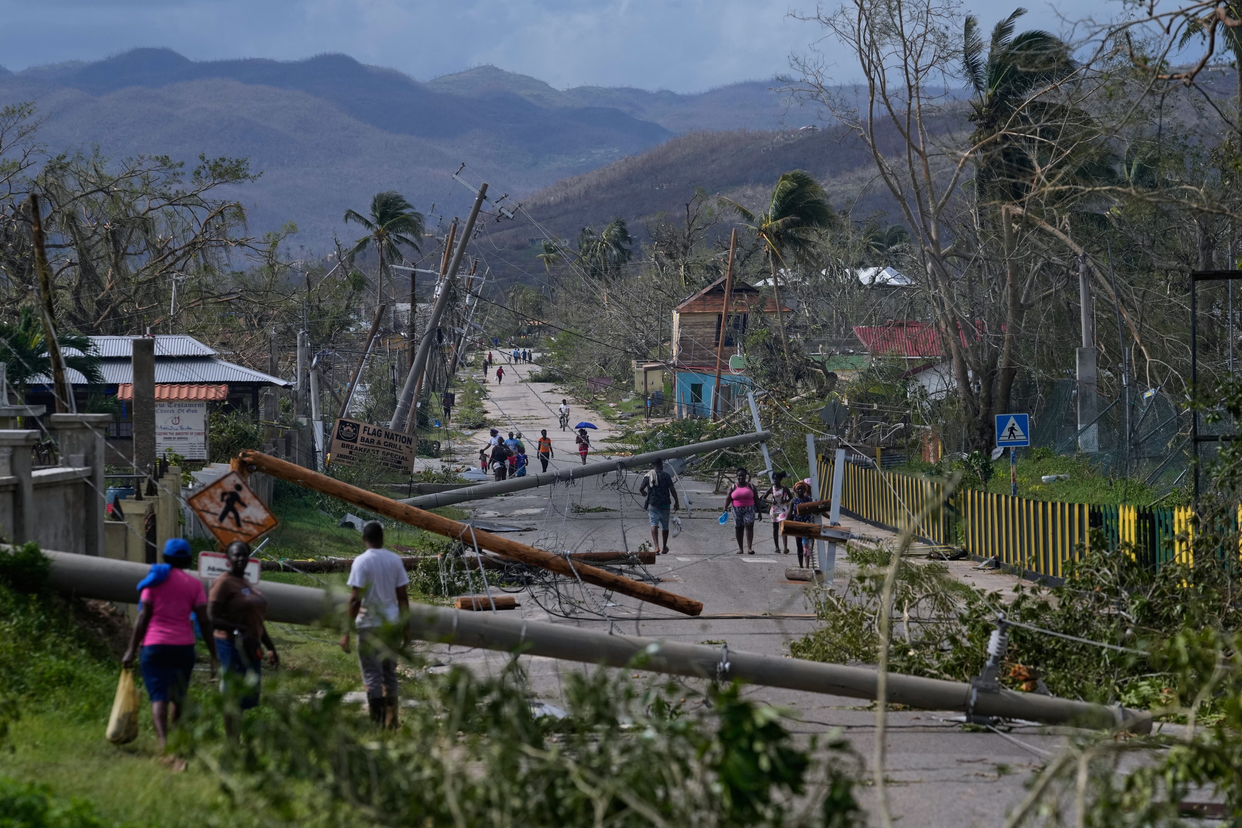 Residents walk through Lacovia Tombstone, Jamaica, in the aftermath of Hurricane Melissa, Wednesday, Oct. 29, 2025.