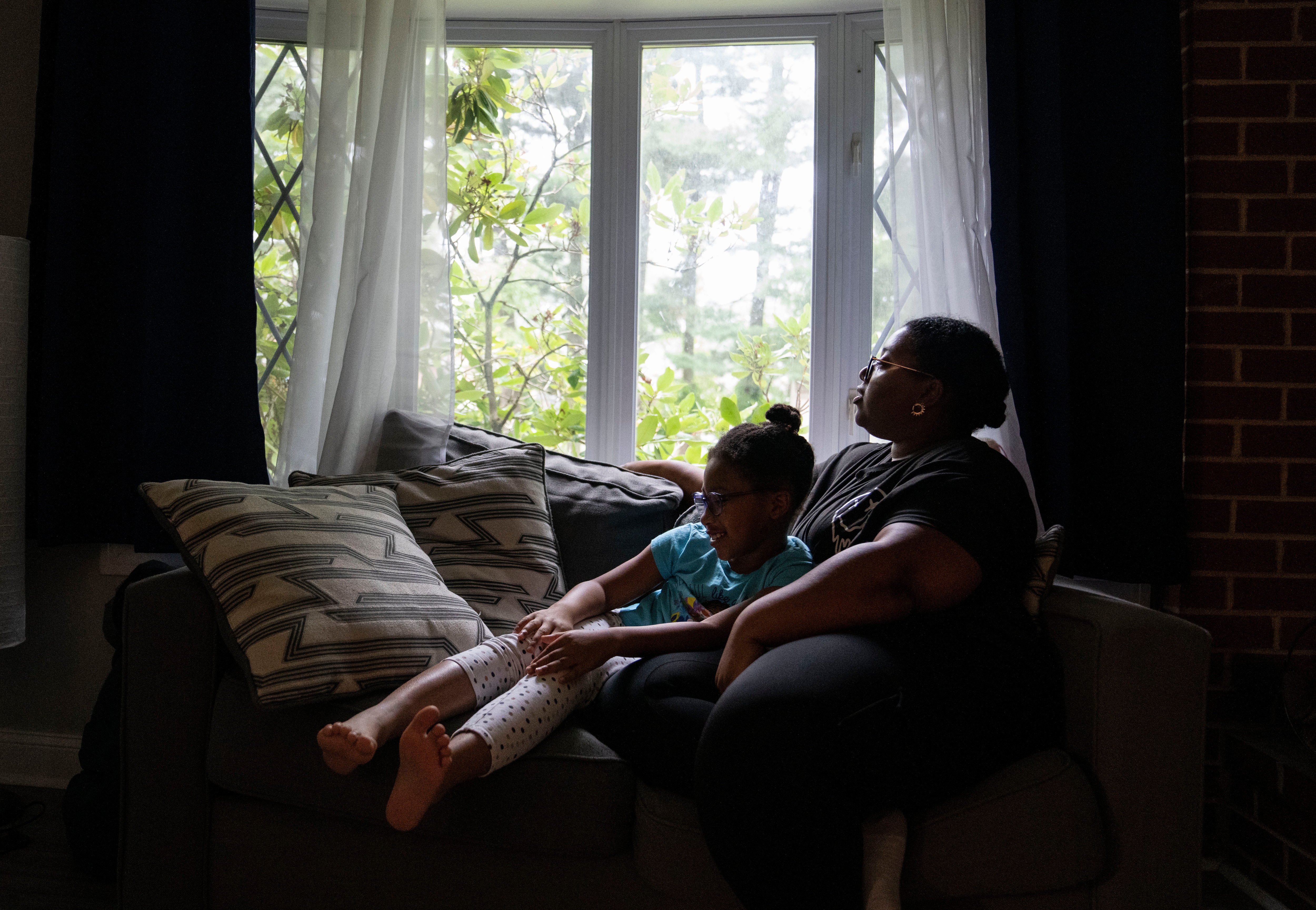 Nazirah Muhammad sits with her daughter Khalilah Muhammad-Debellote, 8, at their home in Randallstown. The family moved there in 2021 for more living space and a slower pace of life.