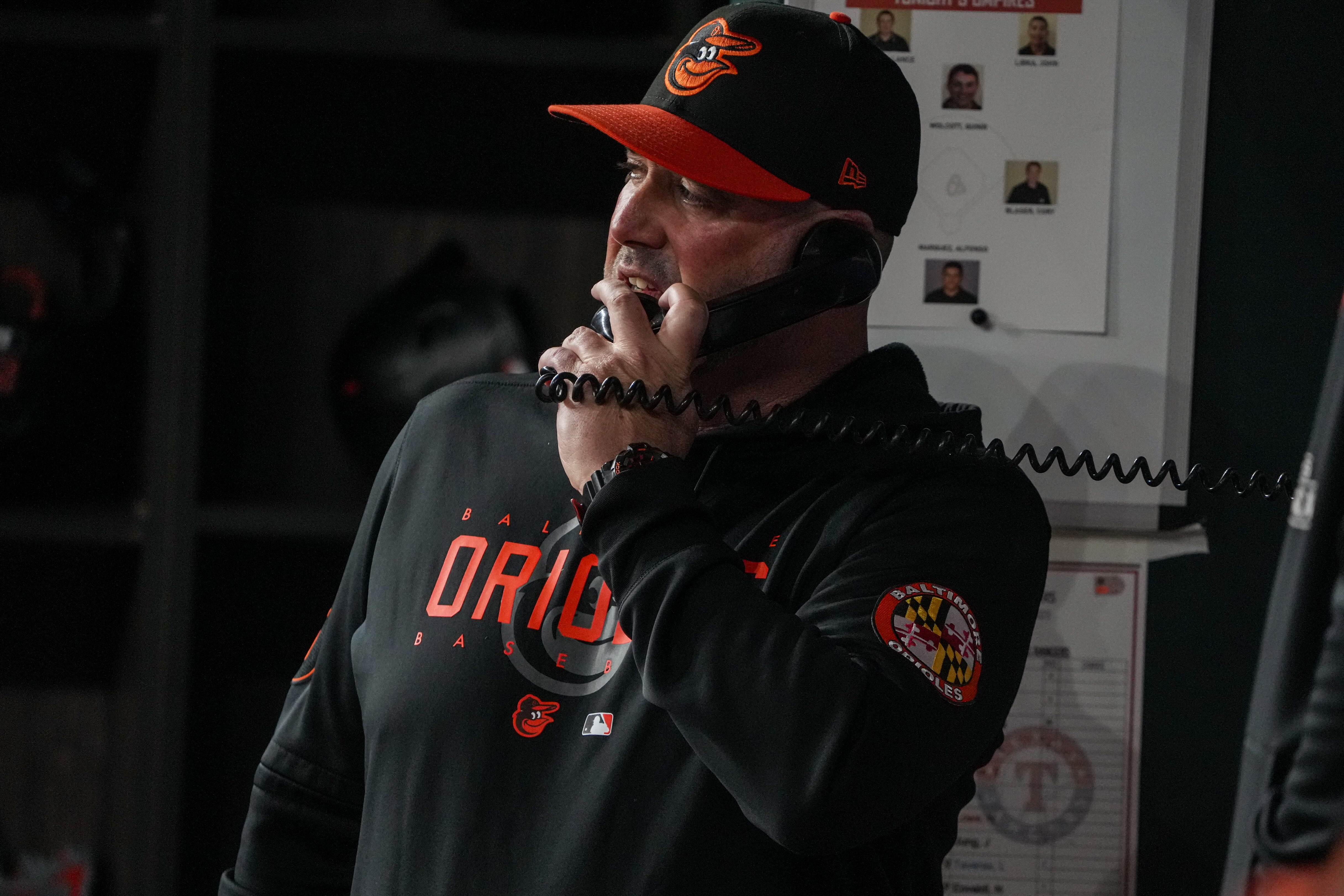 Orioles manager Brandon Hyde checks in with his staff Tuesday during Game 3 of the ALDS in Texas.