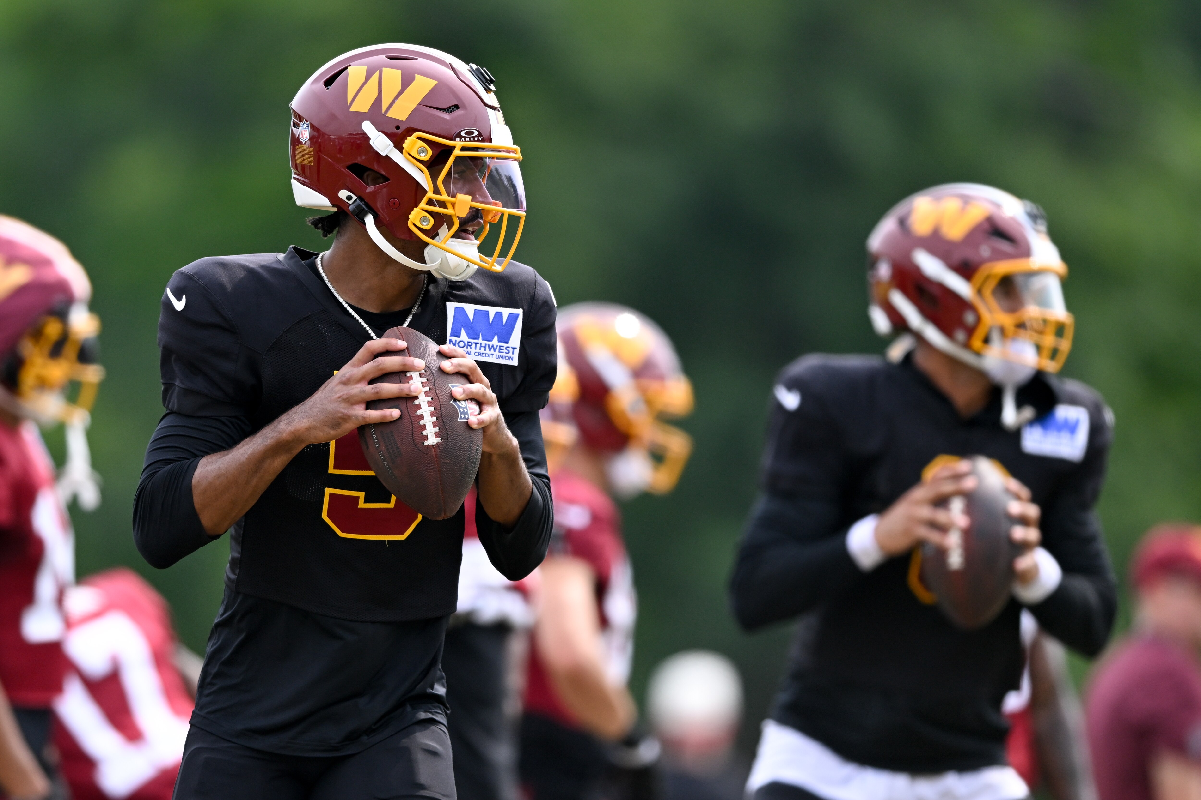 Washington Commanders quarterbacks Jayden Daniels and Marcus Mariota run a drill during training camp in Ashburn earlier this year.