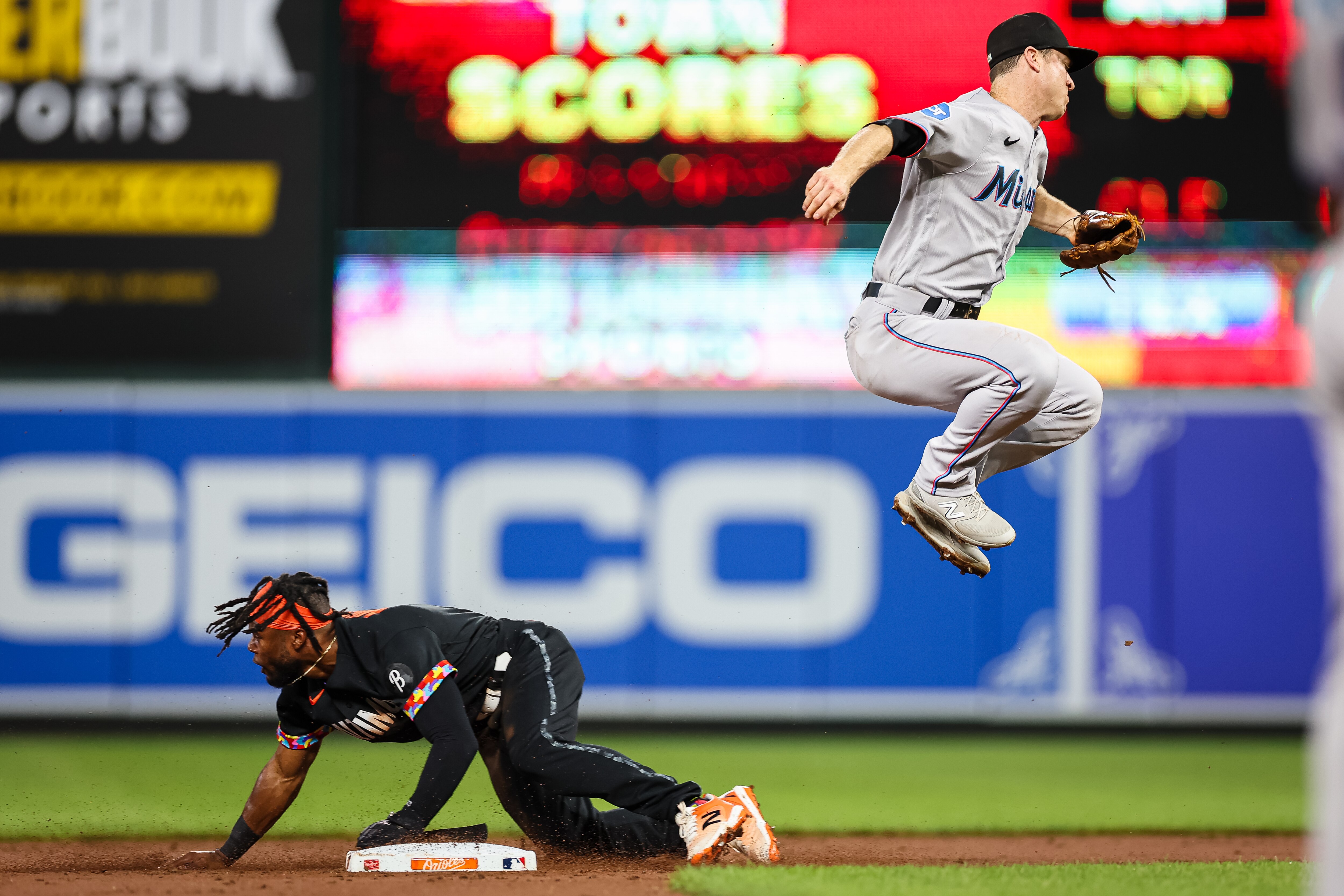 Orioles outfielder Cedric Mullins steals second as Joey Wendle of the Marlins leaps in vain for the throw.