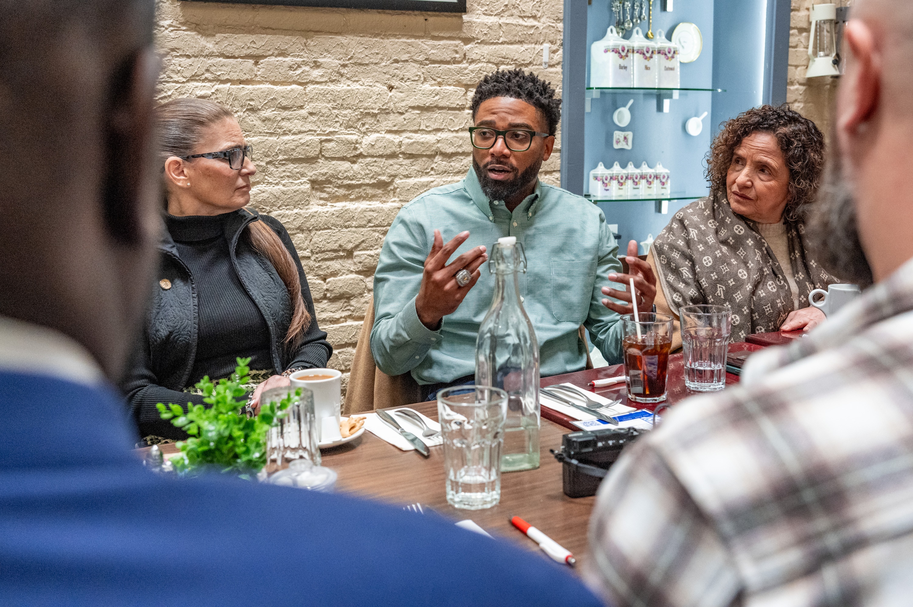 Sunset Raw Juice Bar owner Gerrard Sheppard, center, participates in a roundtable discussion at Twist Fells Point after receiving a grant from the DoorDash Restaurant Disaster Relief Fund.