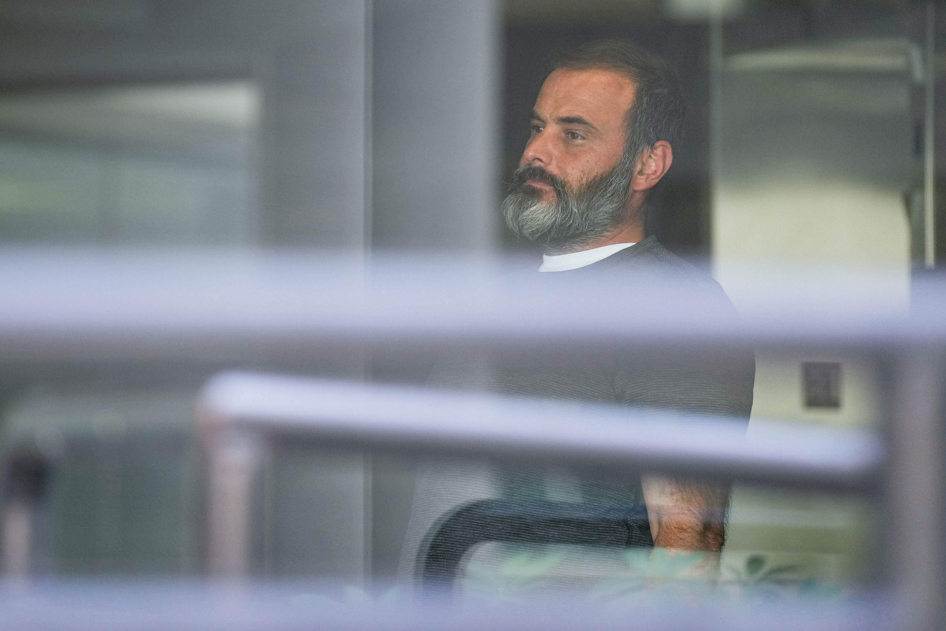 Elias Nick Costianes, seen through a window, prepares to leave the Edward A. Garmatz U.S. District Courthouse in Baltimore last week.