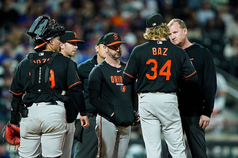 Orioles starter Shane Baz is checked on by manager Craig Albernaz and an athletic trainer before exiting the game with an injury in the fifth inning.