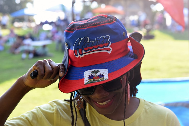 Sherley Cam, who works with the nonprofit Komite Ayiti, shows off her Haitian hat at the Haiti Caribbean Festival on Aug. 9, 2026.