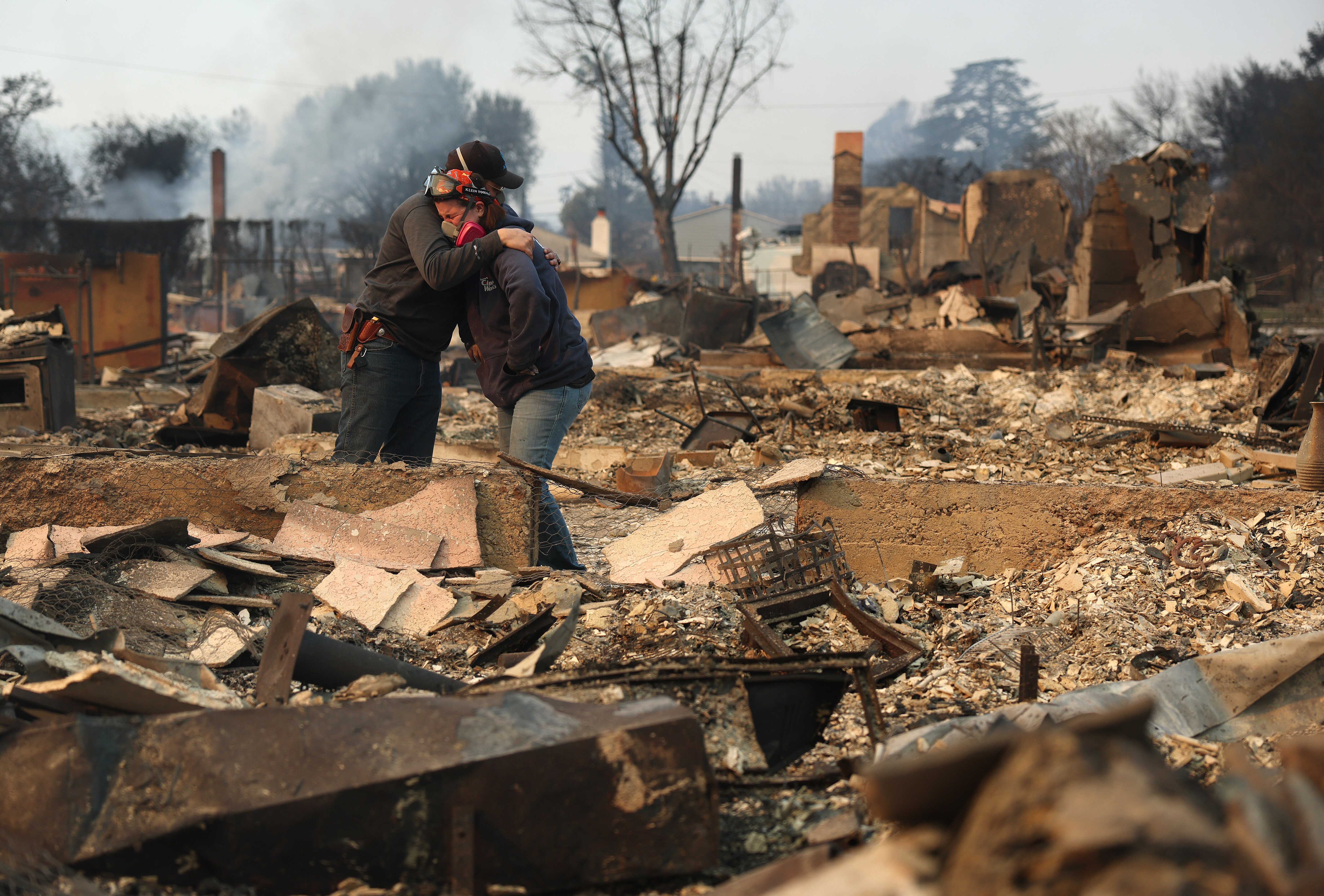 ALTADENA, CALIFORNIA - JANUARY 09: Khaled Fouad (L) and Mimi Laine (R) embrace as they inspect a family member's property that was destroyed by Eaton Fire on January 09, 2025 in Altadena, California. Fueled by intense Santa Ana Winds, the Eaton Fire has grown to over 10,000 acres and has destroyed many homes and businesses. (Photo by Justin Sullivan/Getty Images)