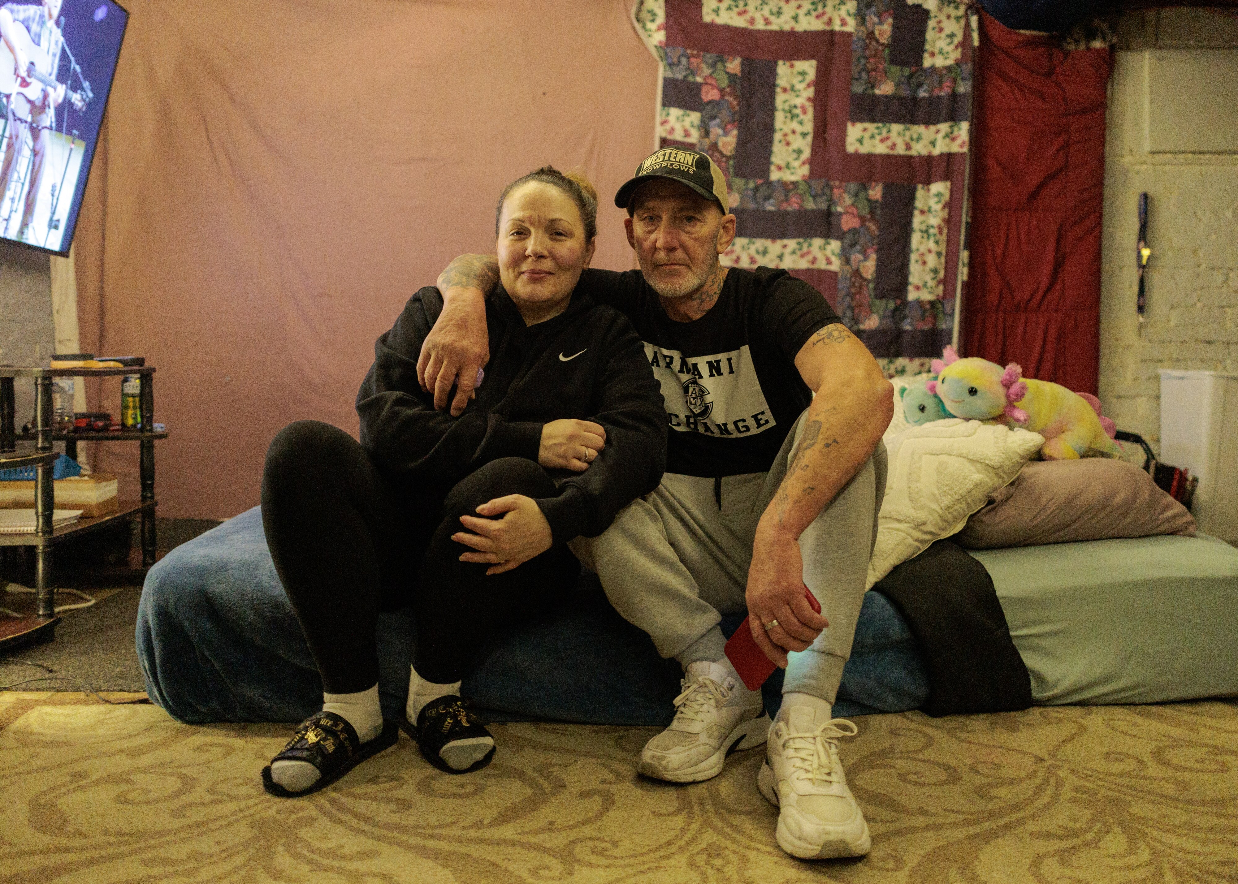 Christina Cikins and her partner David Edge sit on their bed in Baltimore, MD on Jan. 29, 2025. Cikins and Edge are facing homelessness after receiving an unexpected eviction notice.