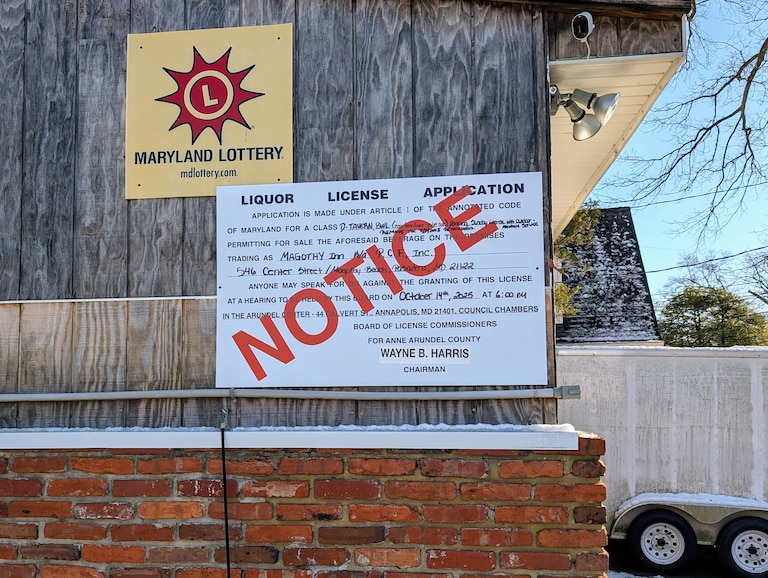 An outdated public notice for a hearing on the Magothy Inn liquor license is still posted on the outside wall.