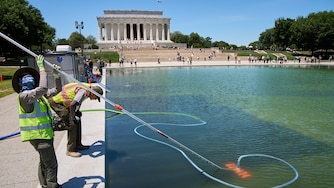 Members of the National Park Service clean algae from the Lincoln Memorial Reflecting Pool, Tuesday, June 16, 2026, in Washington.