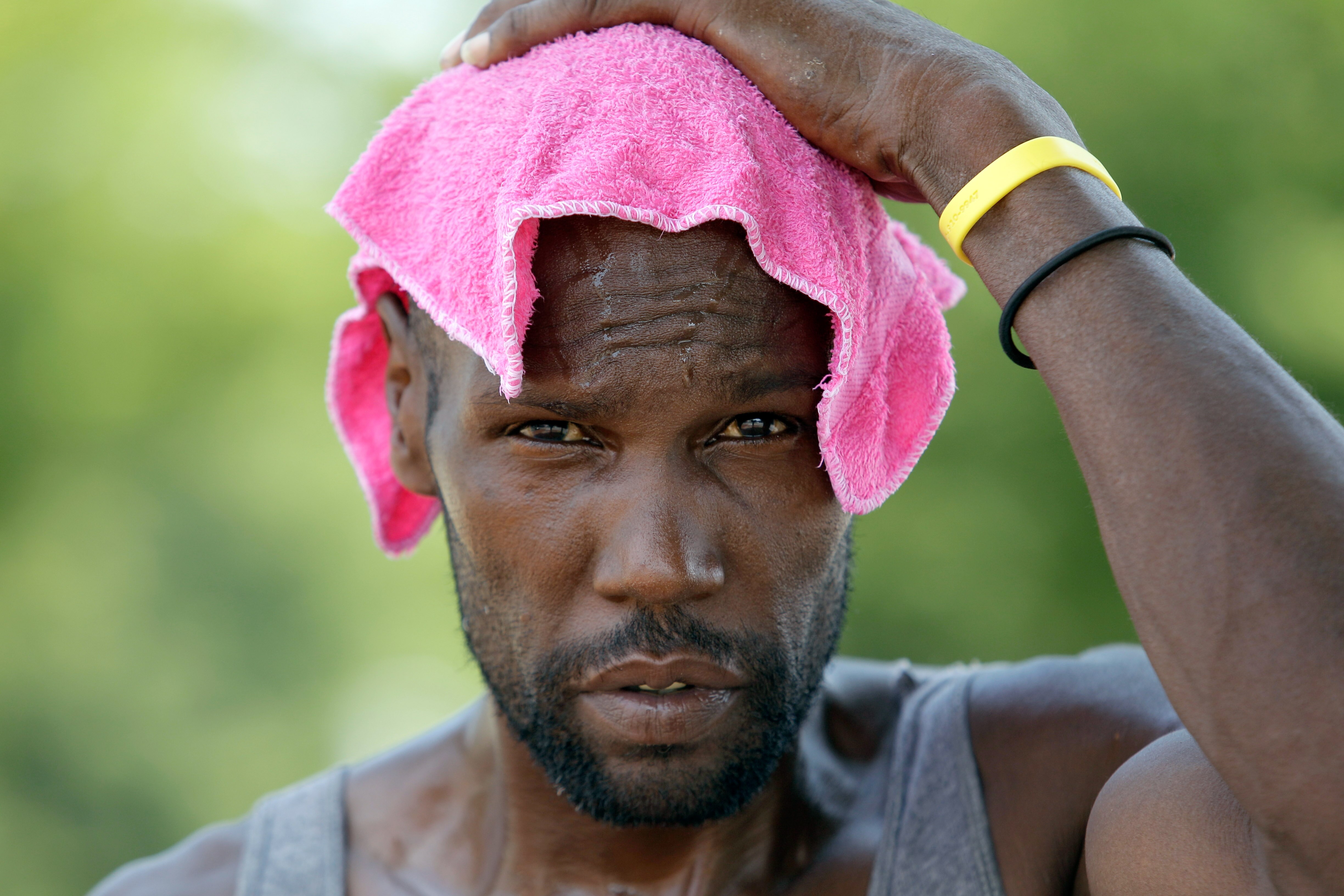 John Rose cools off while selling water to passing motorists on a street corner.