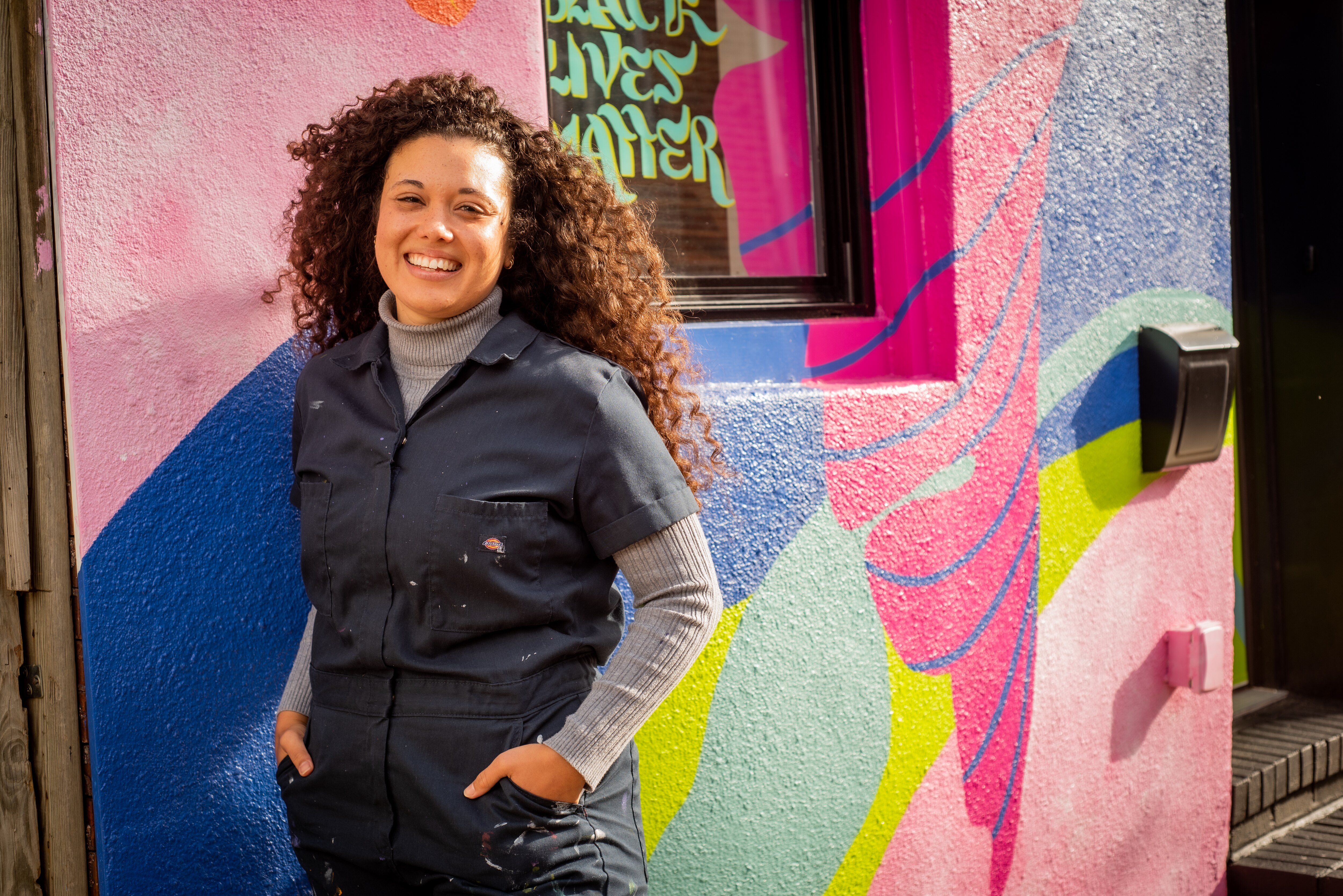 Jaz Erenberg poses for a photo outside of her rowhome that she recently painted.