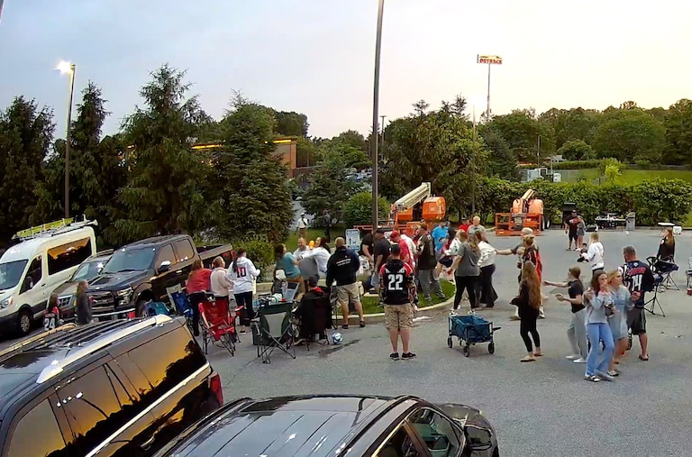 Still from security camera footage as part of legal discovery captures an altercation during a softball tailgate at the center of back and forth criminal charges between a woman and her sister and a group of off-duty police officers.