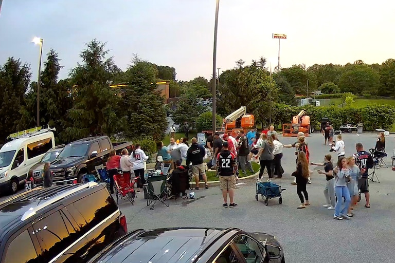 Still from security camera footage as part of legal discovery captures an altercation during a softball tailgate at the center of back and forth criminal charges between a woman and her sister and a group of off-duty police officers.
