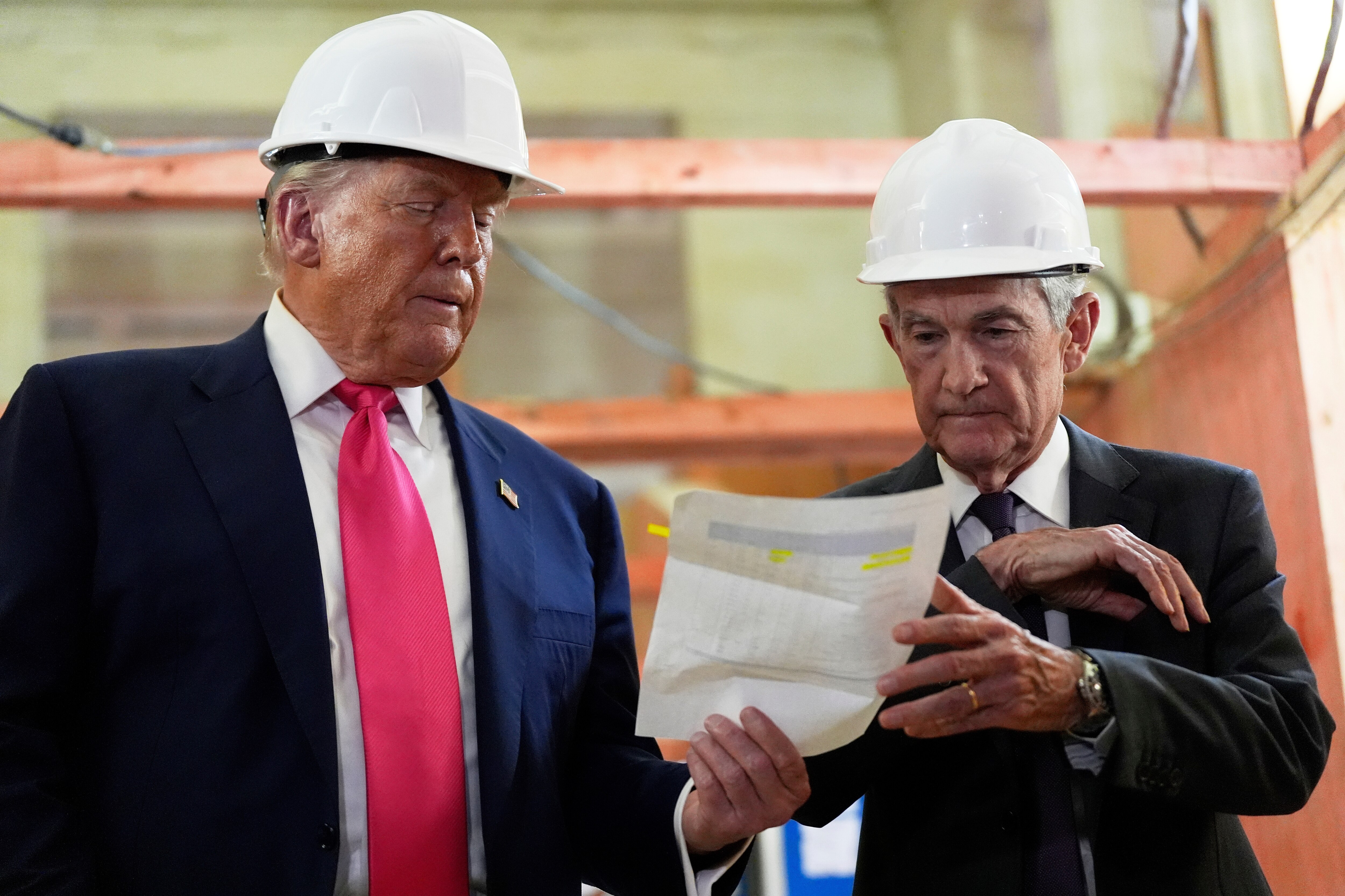 Federal Reserve Chairman Jerome Powell and President Donald Trump look over a document of cost figures during a visit to the Federal Reserve.