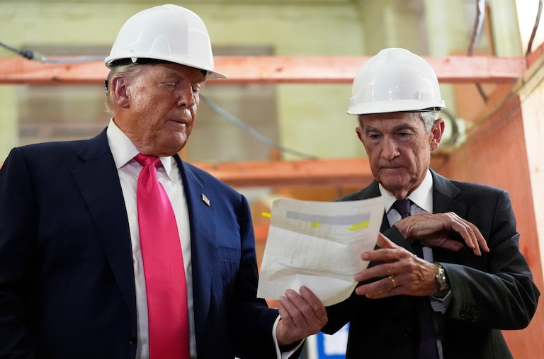 Federal Reserve Chairman Jerome Powell and President Donald Trump look over a document of cost figures during a visit to the Federal Reserve.